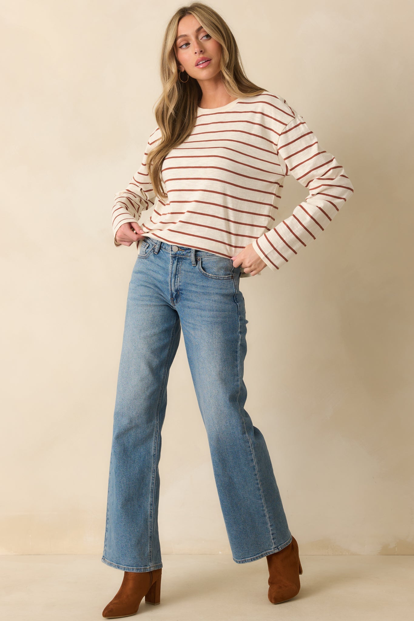 Front-facing full body view of an ivory long sleeve top with cinnamon brown horizontal stripes and a relaxed fit.