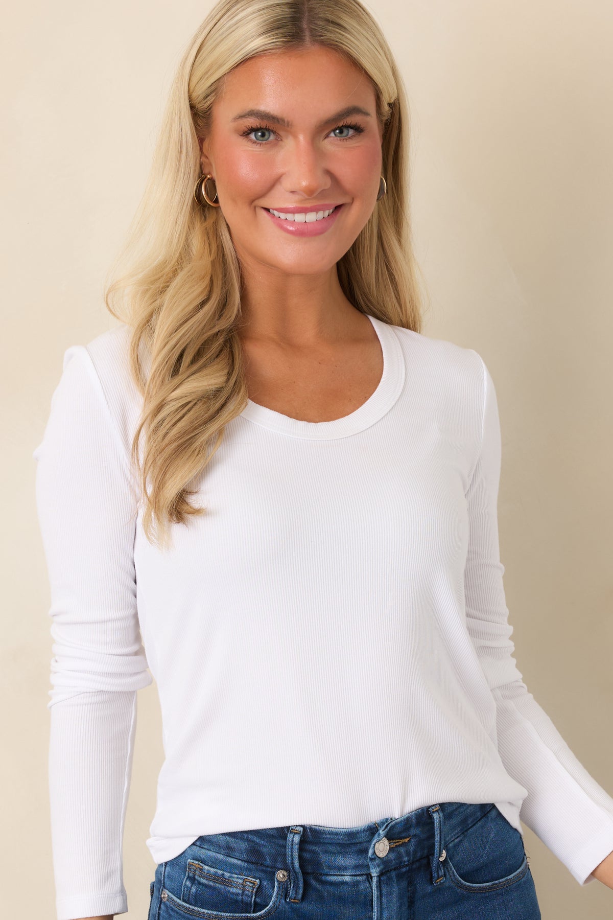 Upper portion of the long-sleeve ivory top showcasing the rounded neckline and relaxed fit.