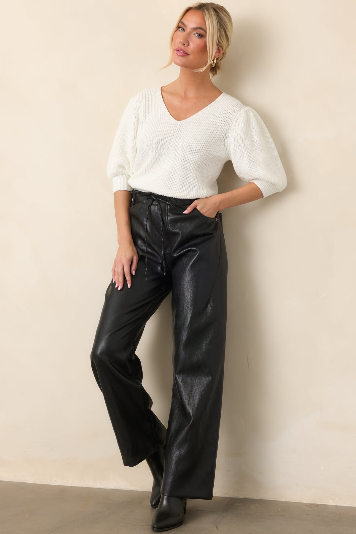 Ivory top featuring a V-neckline, lightly gathered shoulders, puff sleeves, and wide ribbed cuffs.