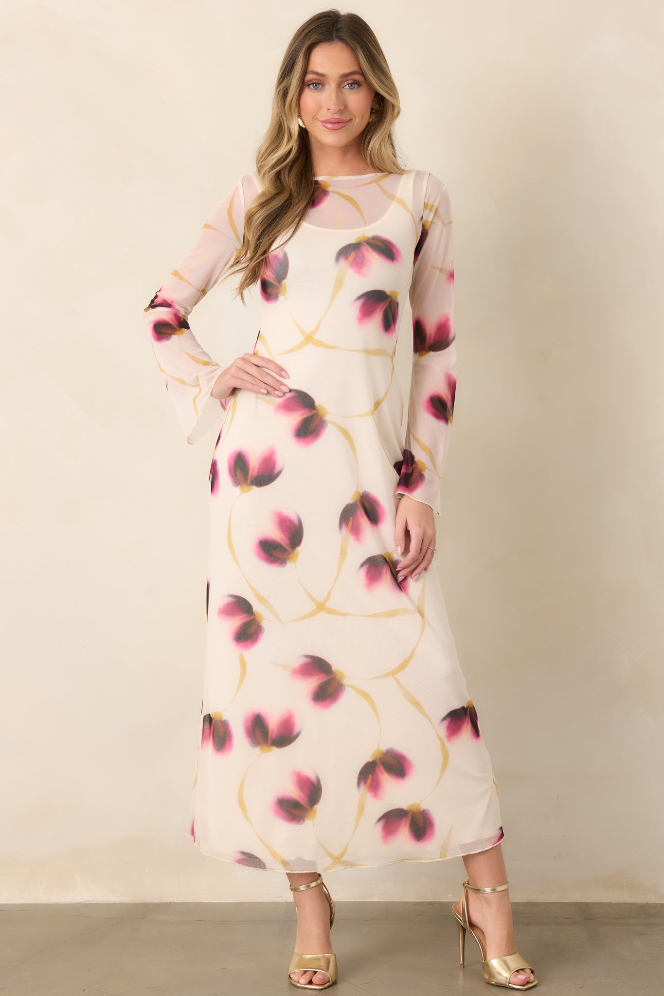 Ivory mesh dress adorned with soft wine, pink, and golden floral accents, designed with a fitted silhouette and polished full-length hem.