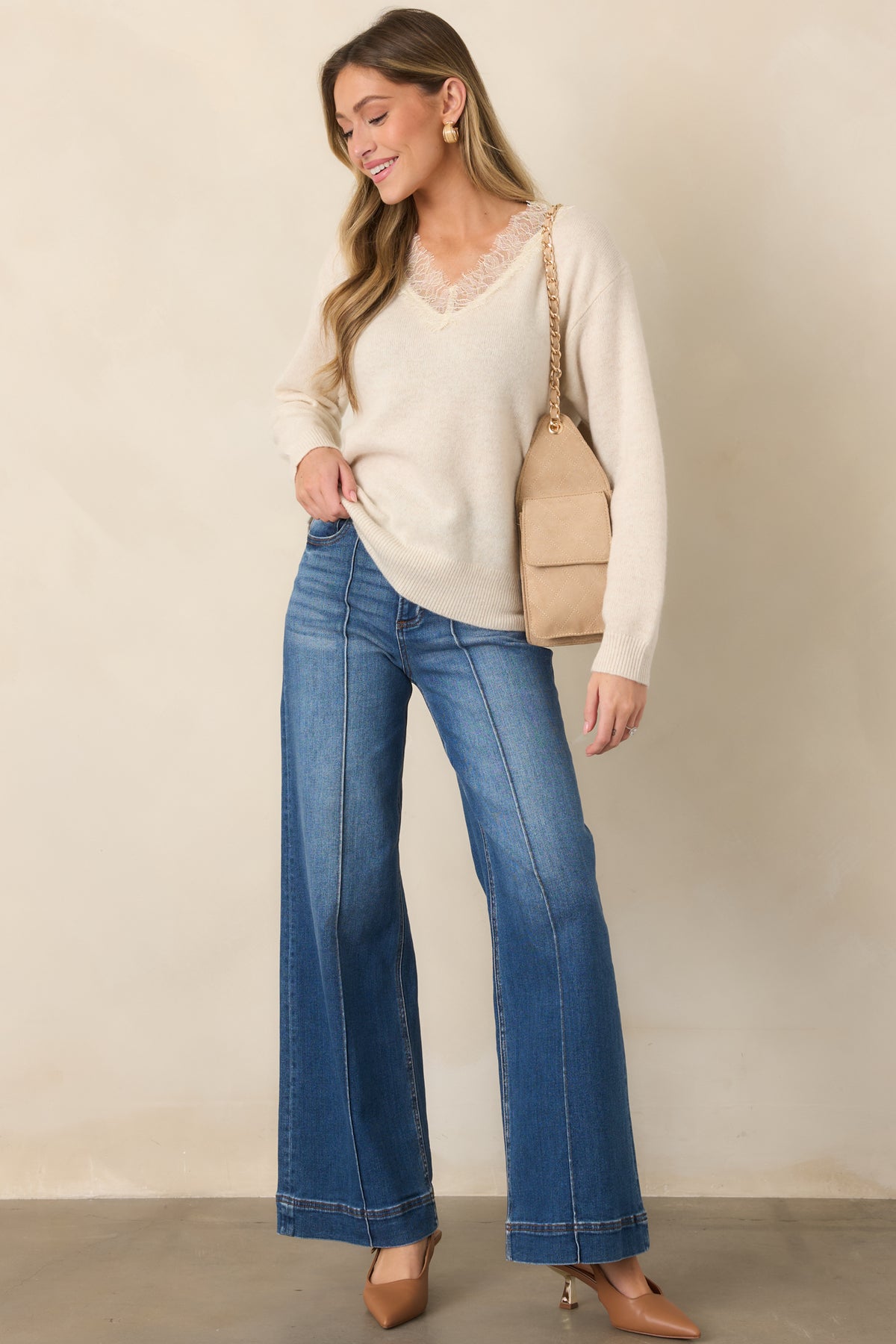 Ivory wool sweater featuring a flattering V-neckline with lace trim.
