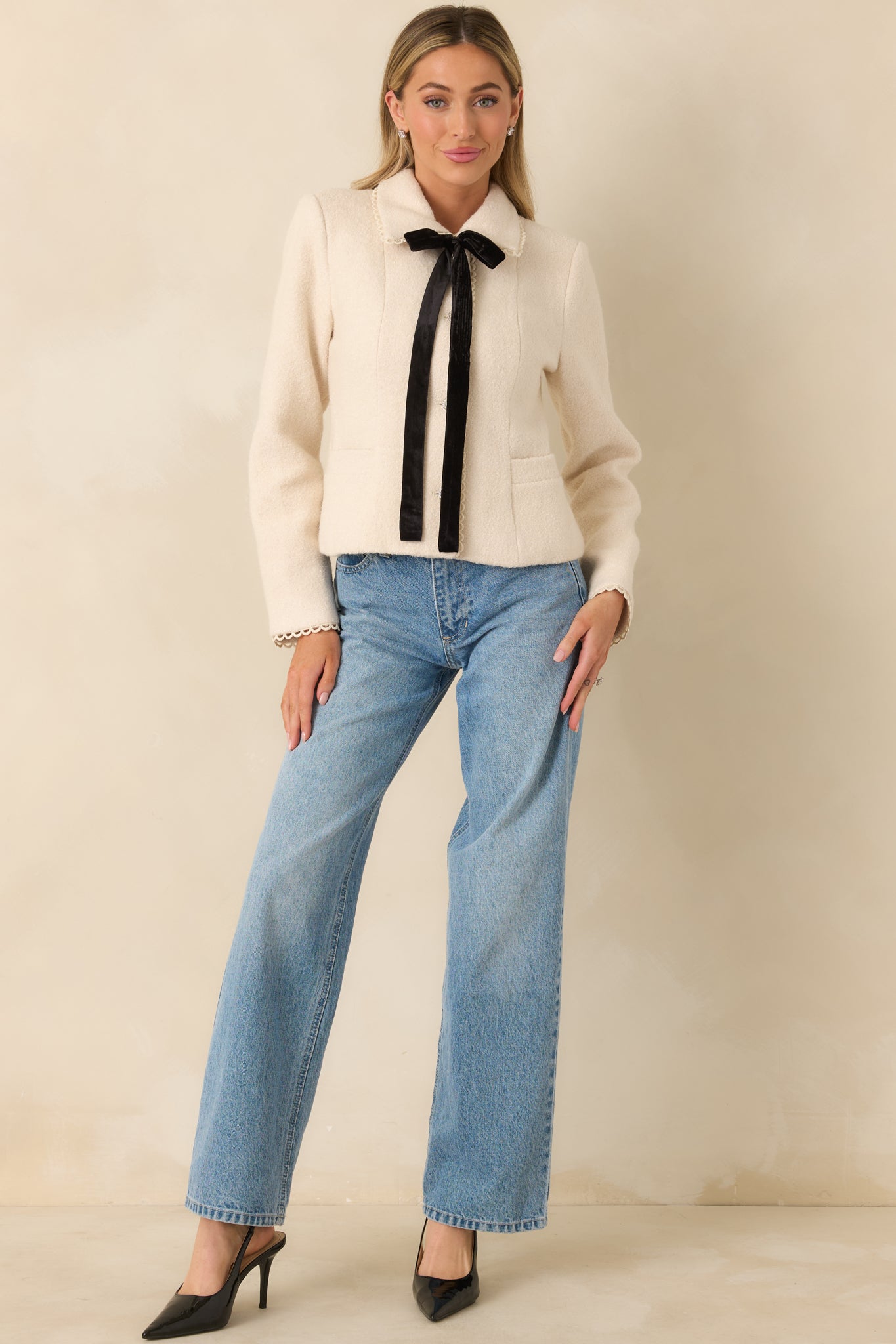 Tailored jacket in soft natural wool with scalloped collar trim, long sleeves, and front patch pockets.