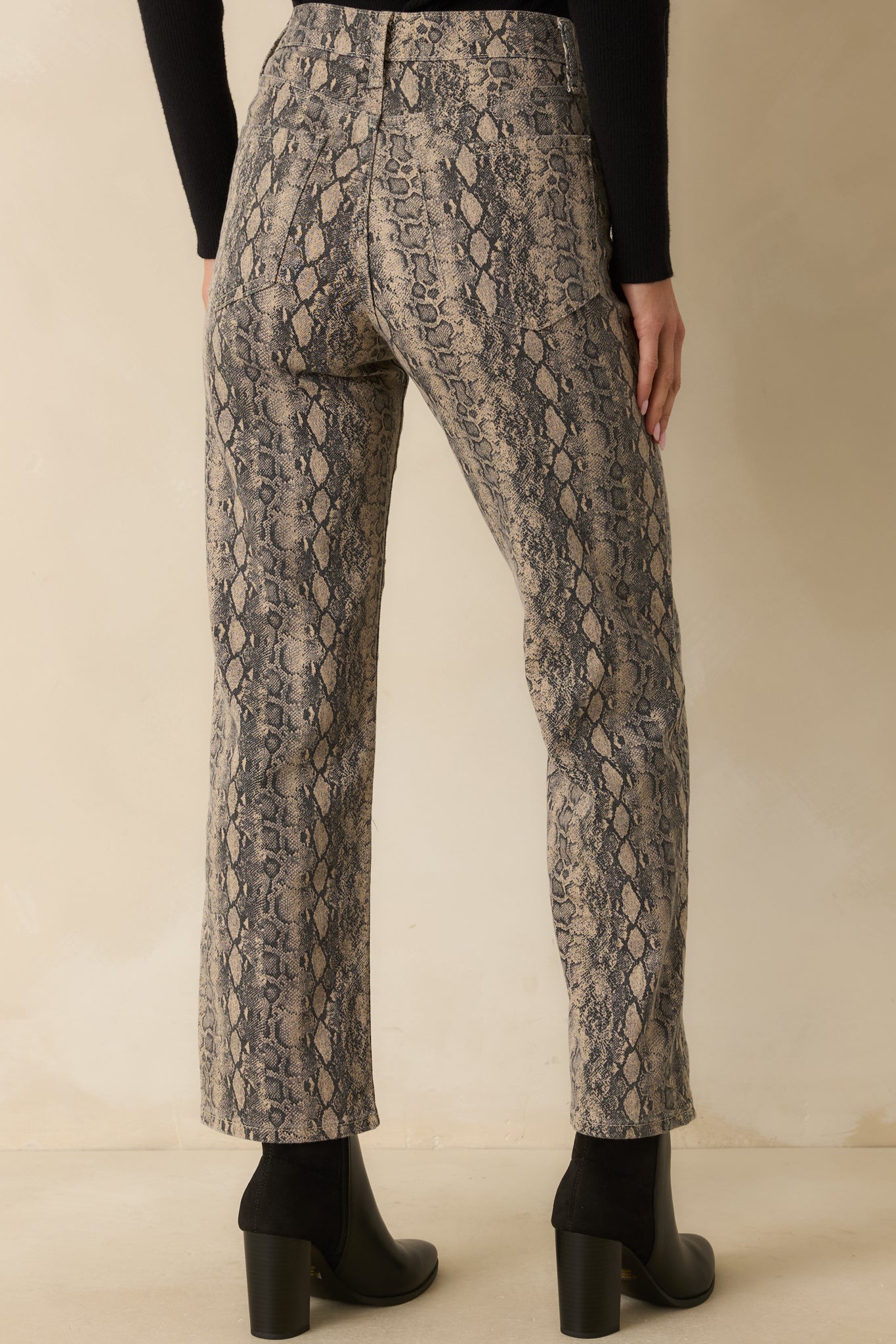 Rear view of the jeans showing the functional back patch pockets and full snakeskin print.