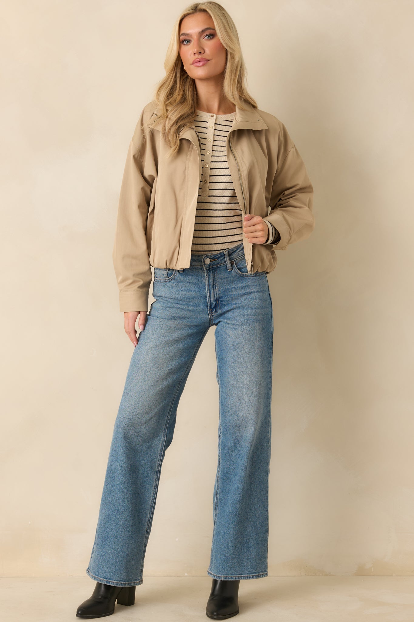 Khaki bomber jacket with a smooth woven shell, zip-front closure, and stand collar with snap detail.