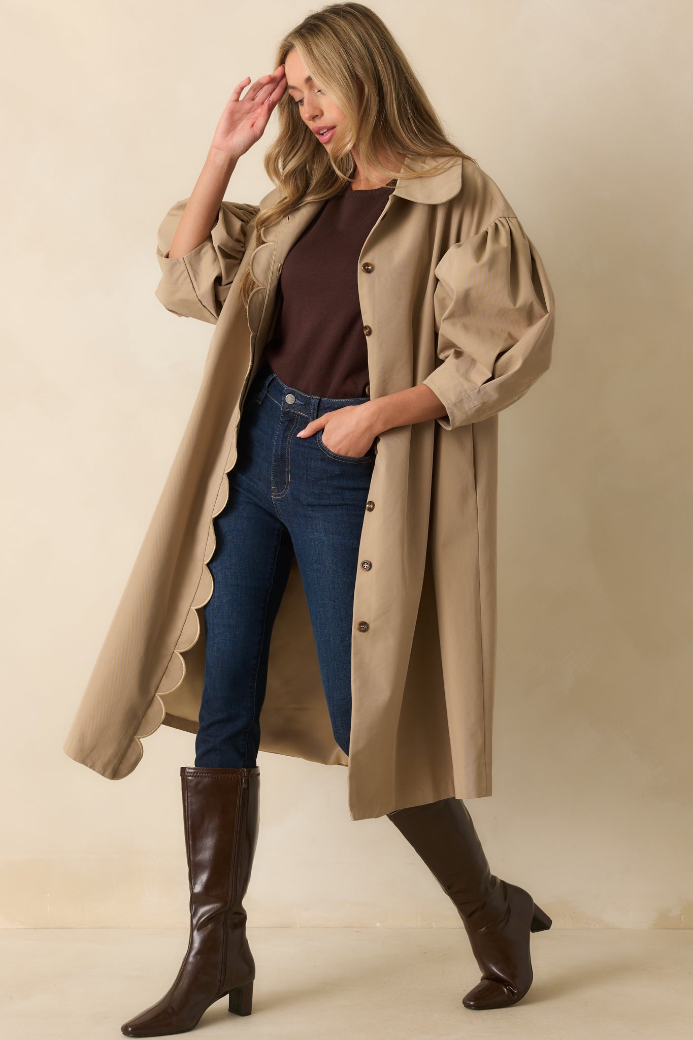 Khaki coat with a collar neckline and scalloped trim, styled with a relaxed silhouette.