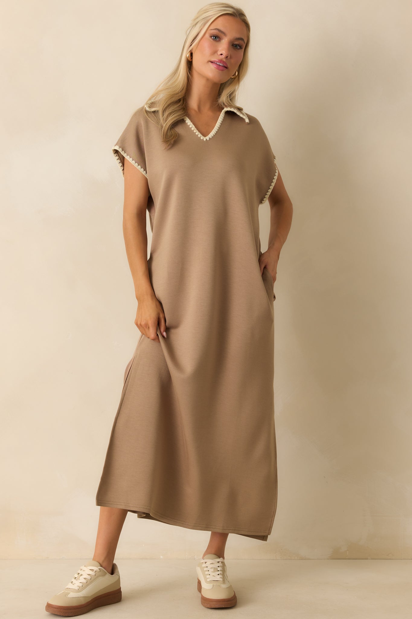 Knit tan dress highlighted by a pointed collar and ivory contrast stitching details.