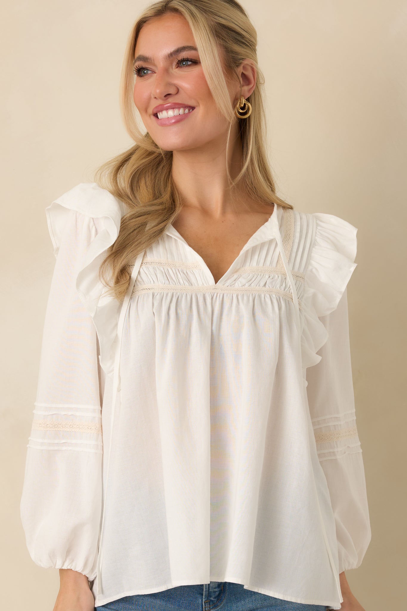 Lace inset panel and soft woven texture on the white flowy blouse.
