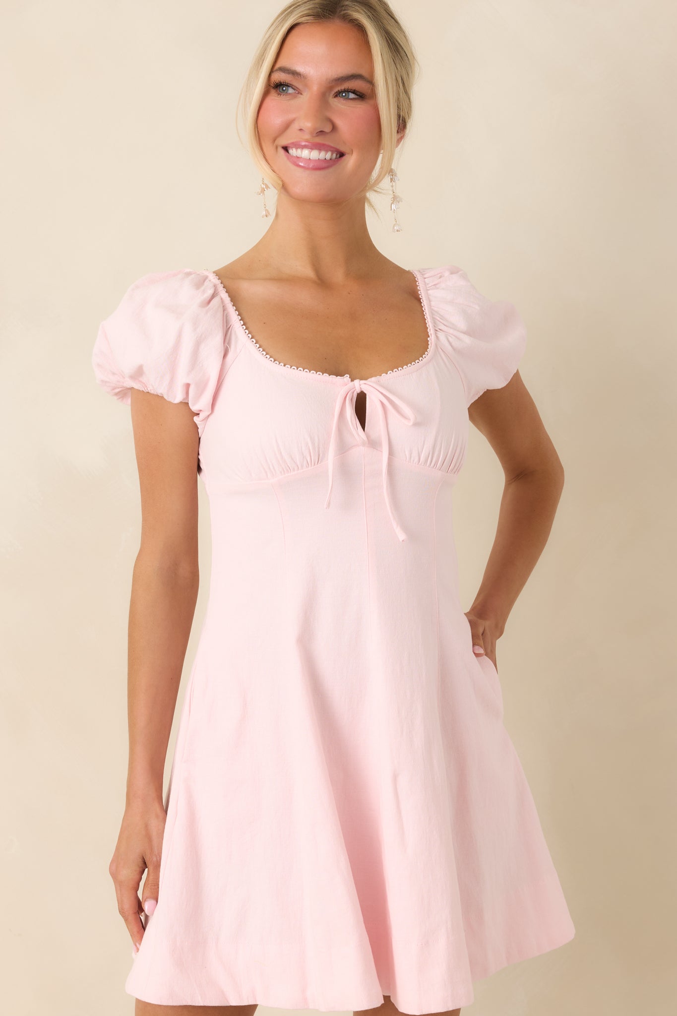 Lace-trimmed neckline and gathered bust detail on a breathable pink mini dress.