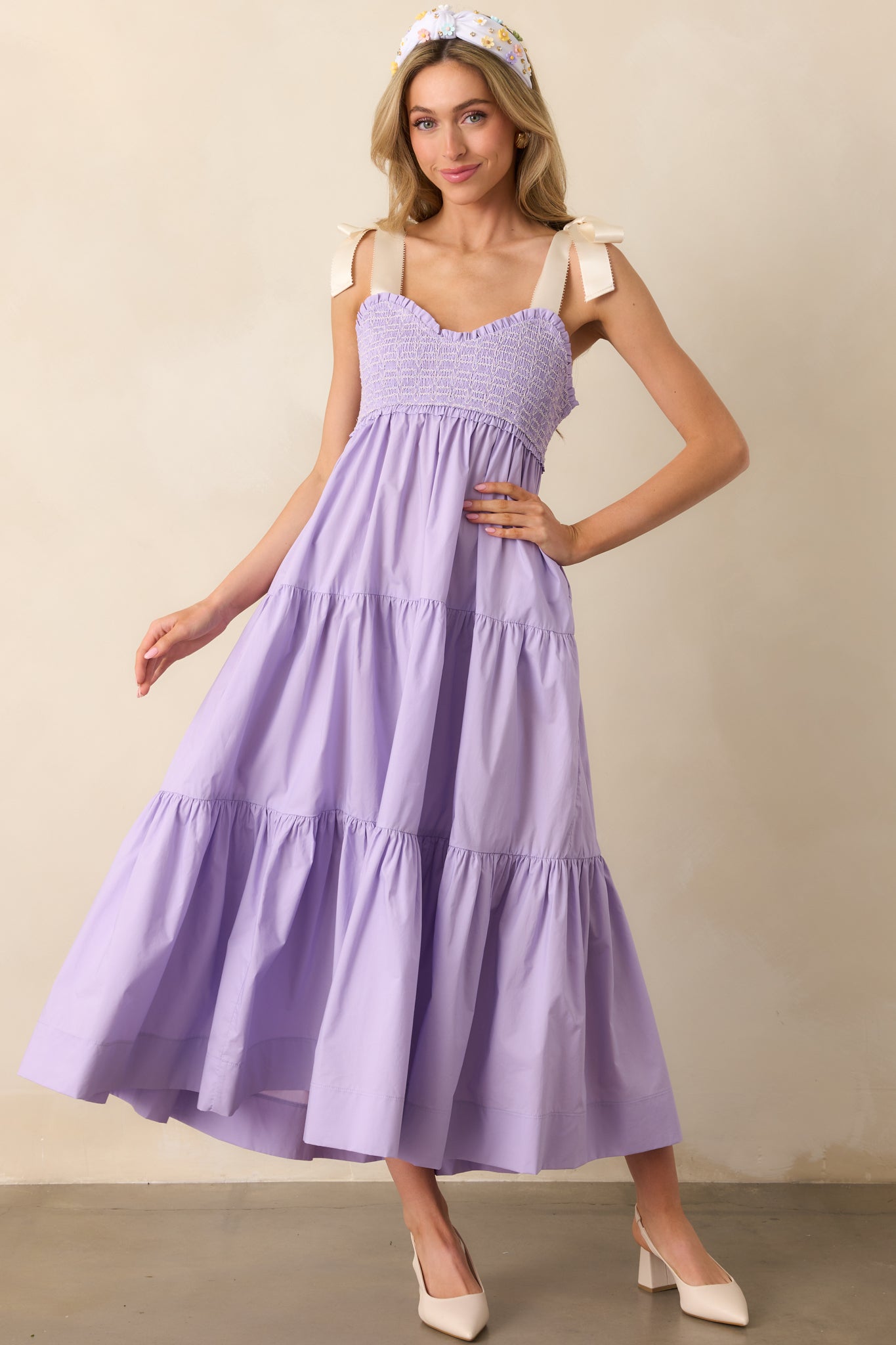 Breezy and elegant, this lavender midi dress combines a fitted smocked bodice with a flowing skirt and hidden functional pockets.