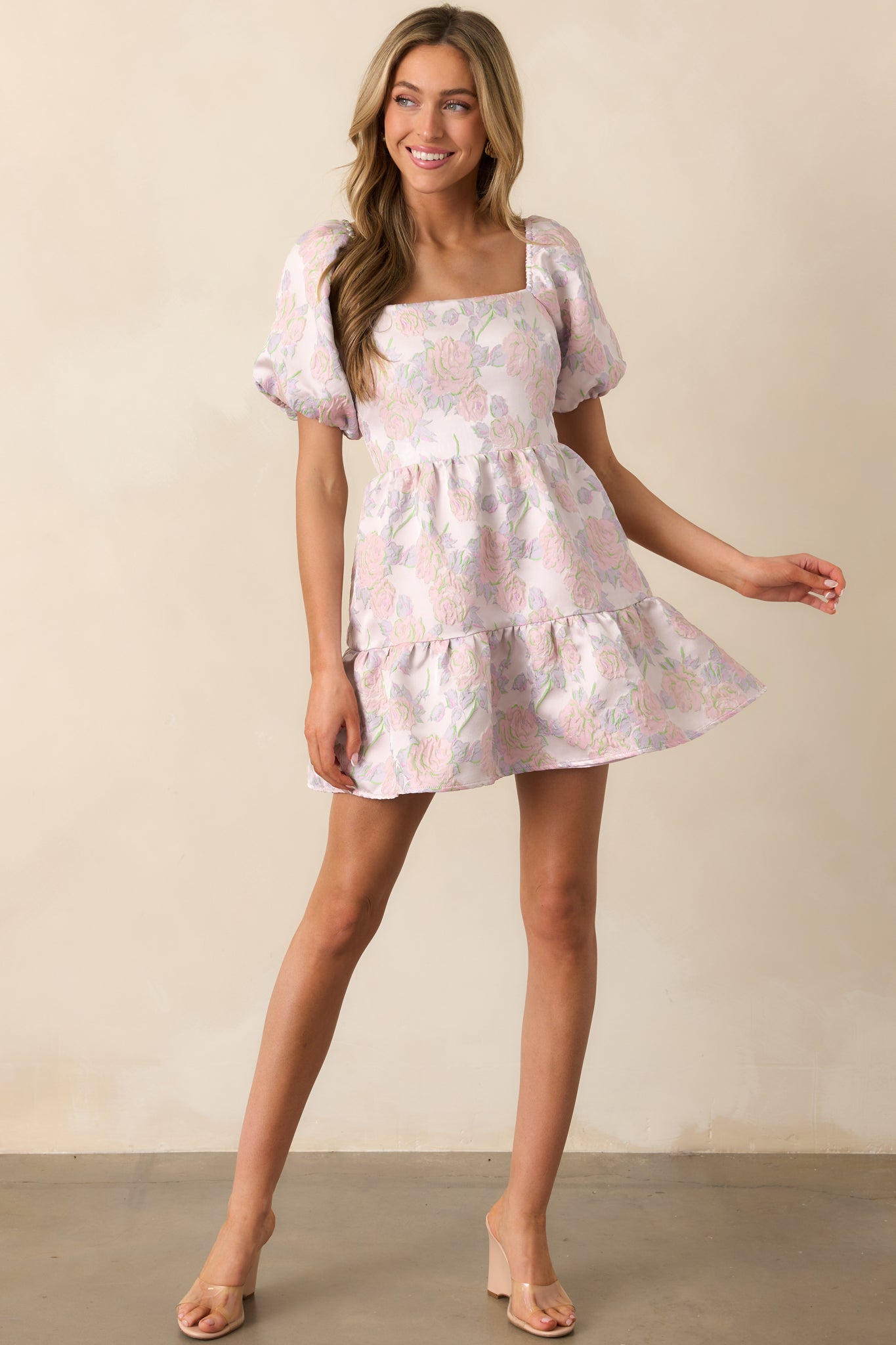 A lavender mini dress with a floral jacquard fabric, square neckline, and tiered design, creating a soft and elegant silhouette.