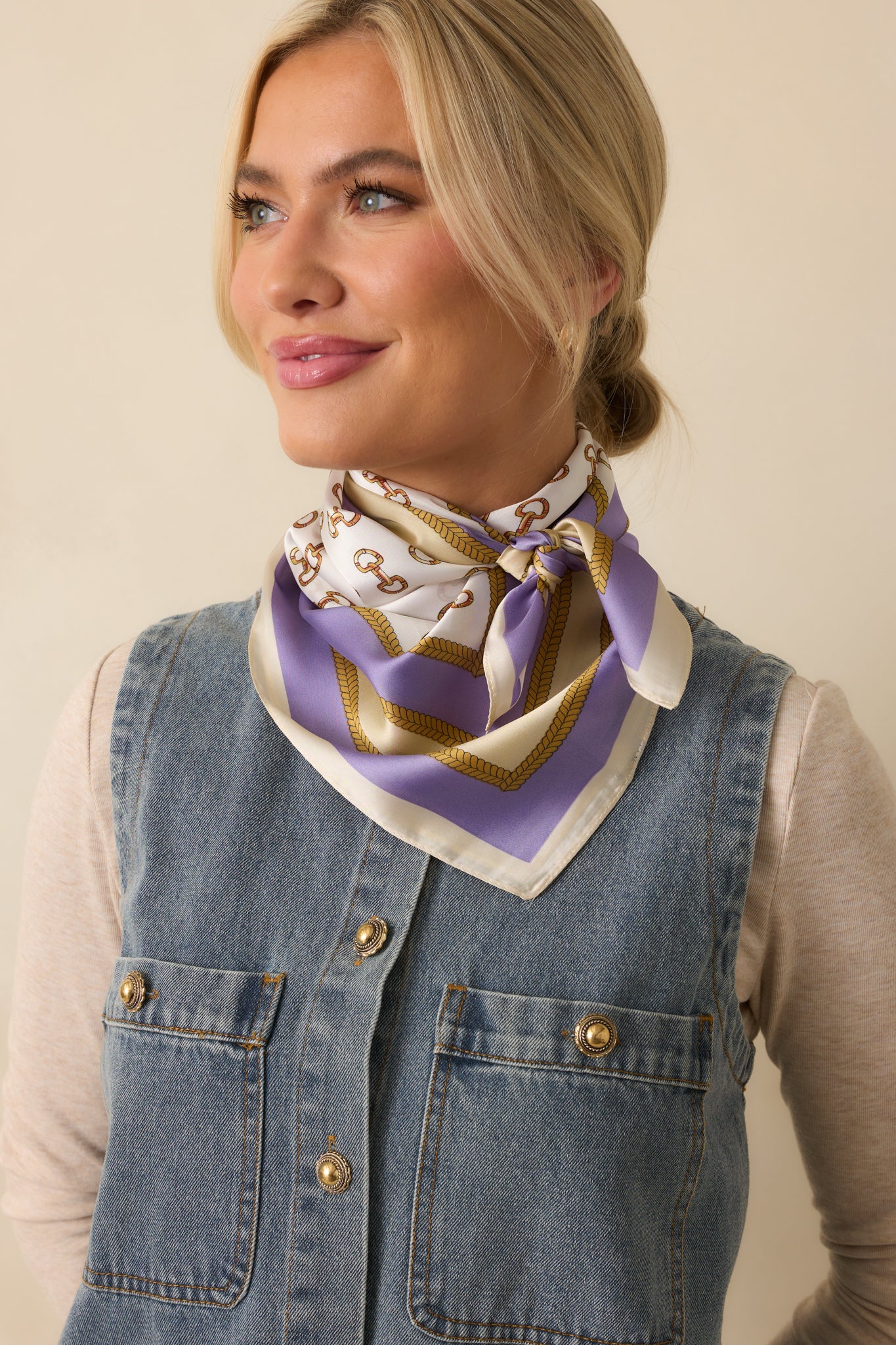 Scarf styled around the neck showing the lavender base, gold snaffle bit pattern, and chain border.