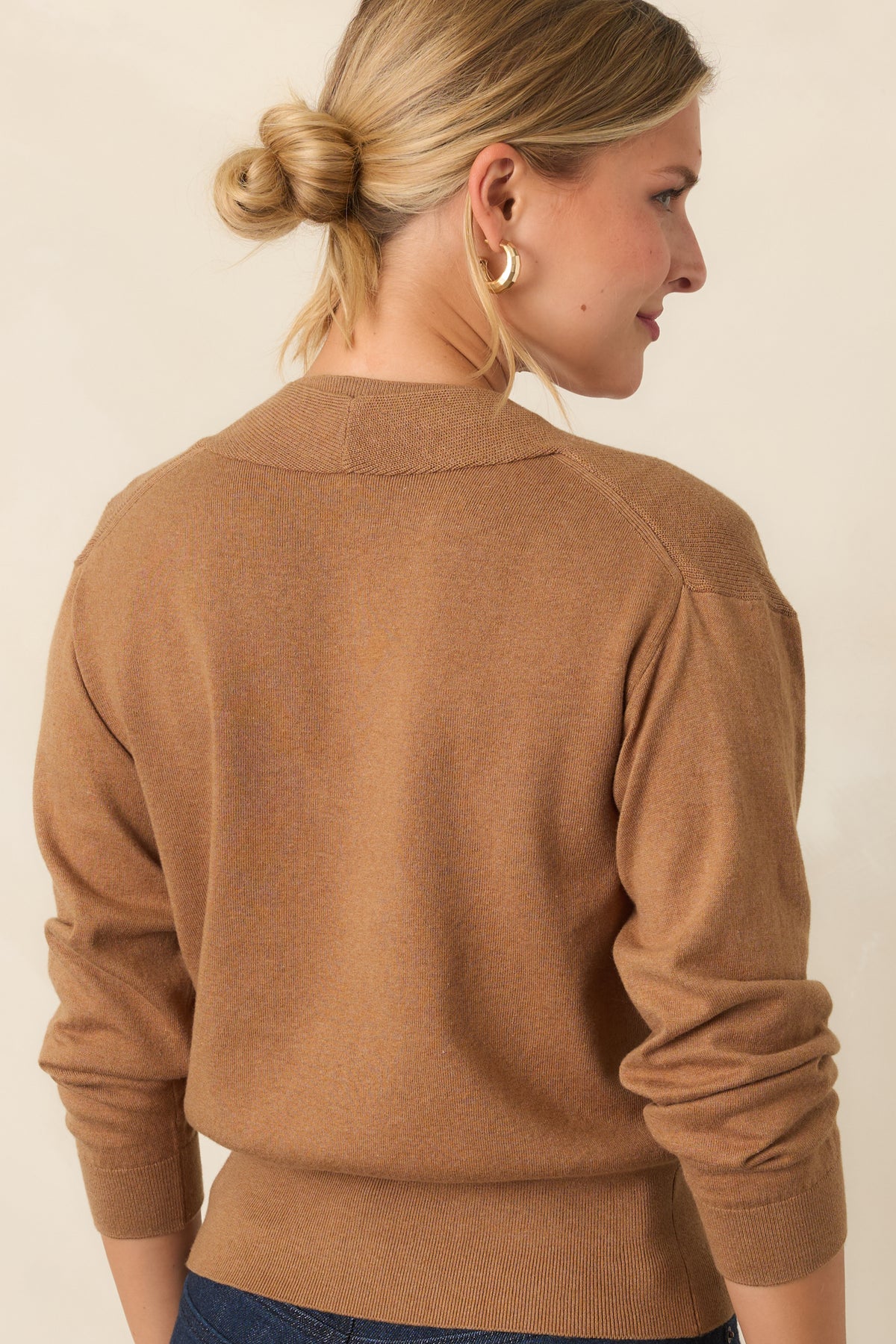 Rear of the layered knit top showing the sleeveless sweater base and long-sleeve overlay.