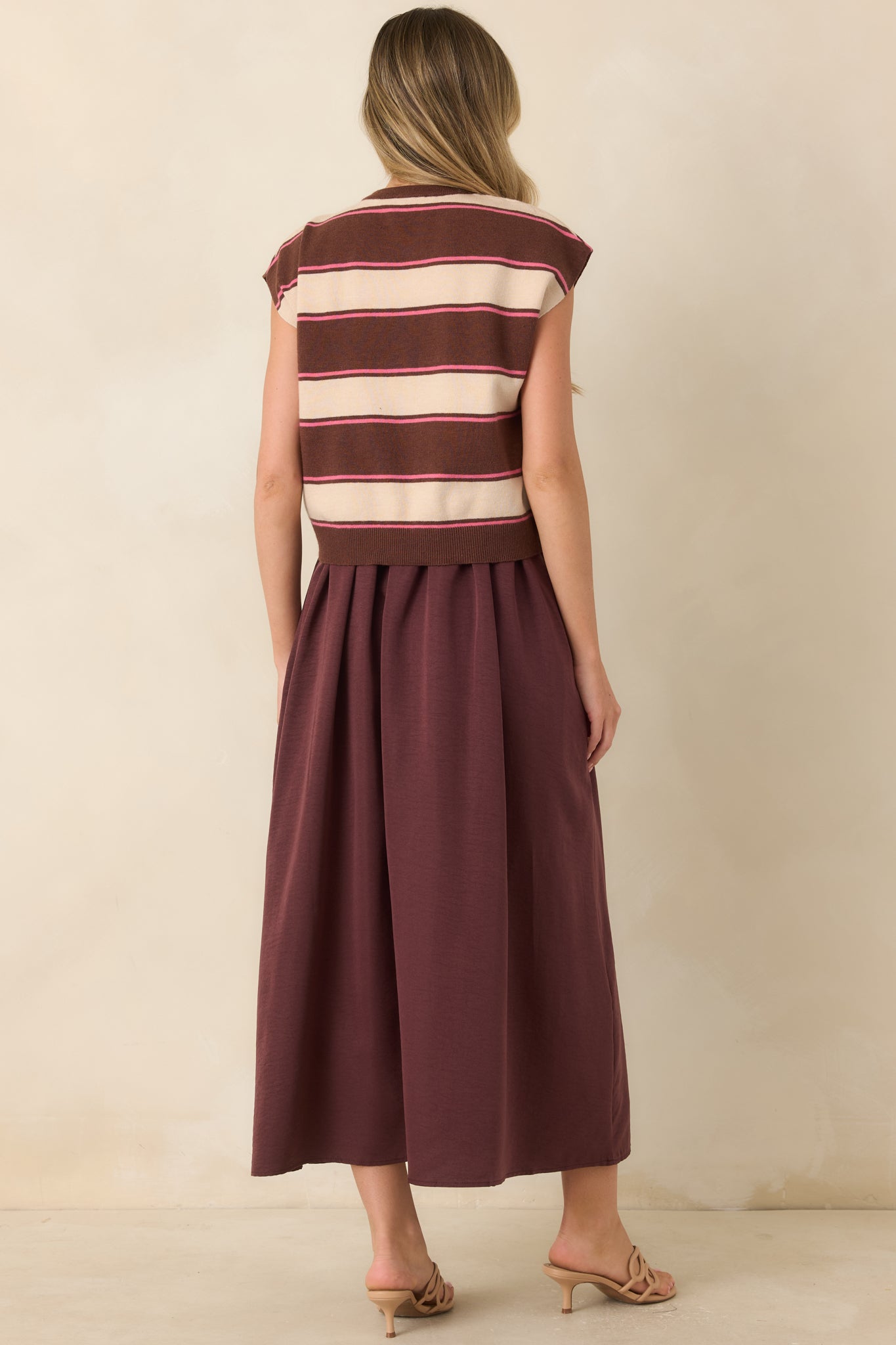 Back view of the layered maxi dress featuring the attached sweater overlay and a flowing full-length skirt silhouette.