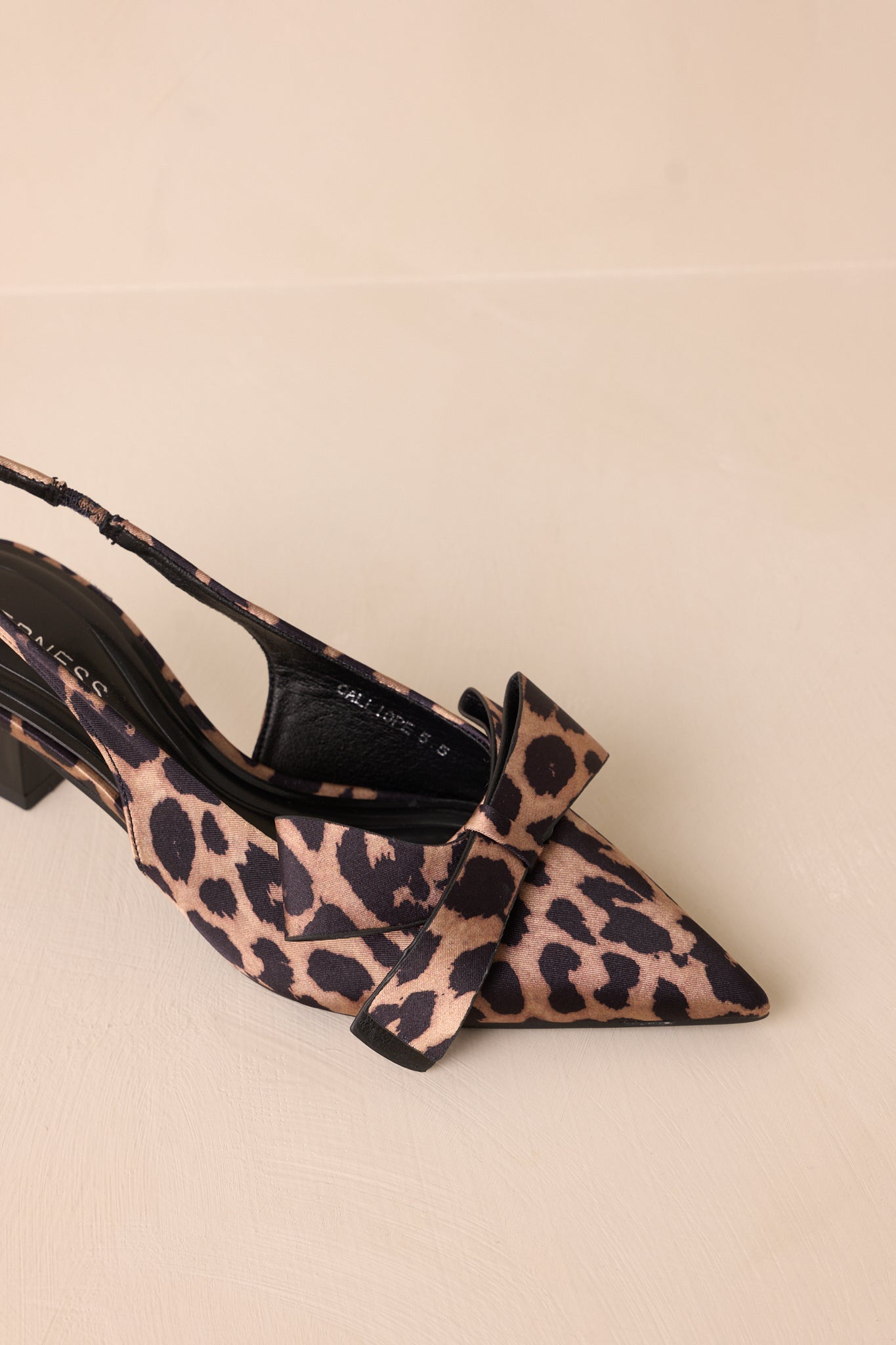 A close-up of the gorgeous bow detail on the leopard heels, showcasing the texture and craftsmanship that enhance their overall elegance.
