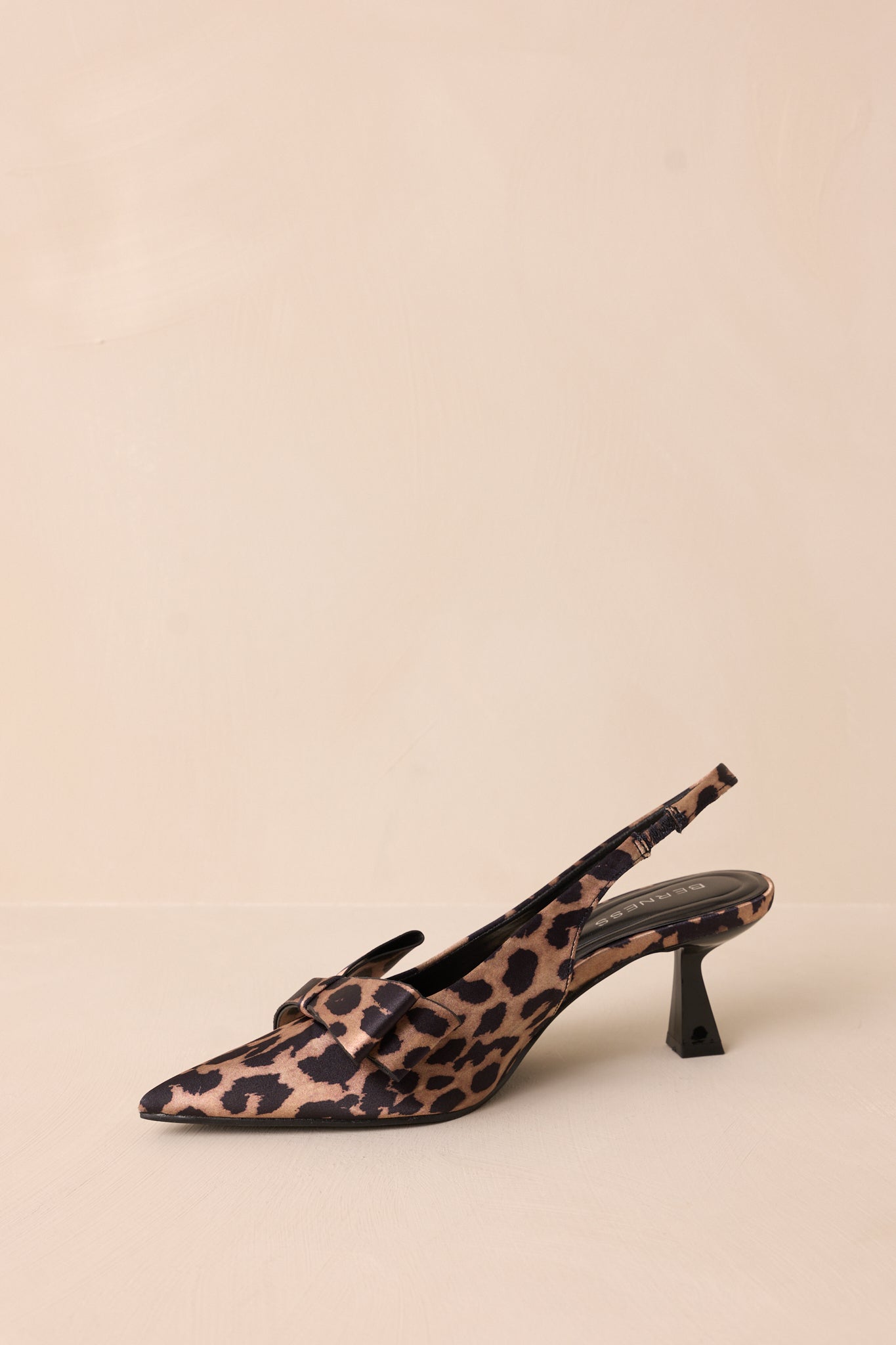 A side view of the leopard heels, emphasizing the bow on the toe & the slingback strap that adds a chic touch while ensuring a secure fit.