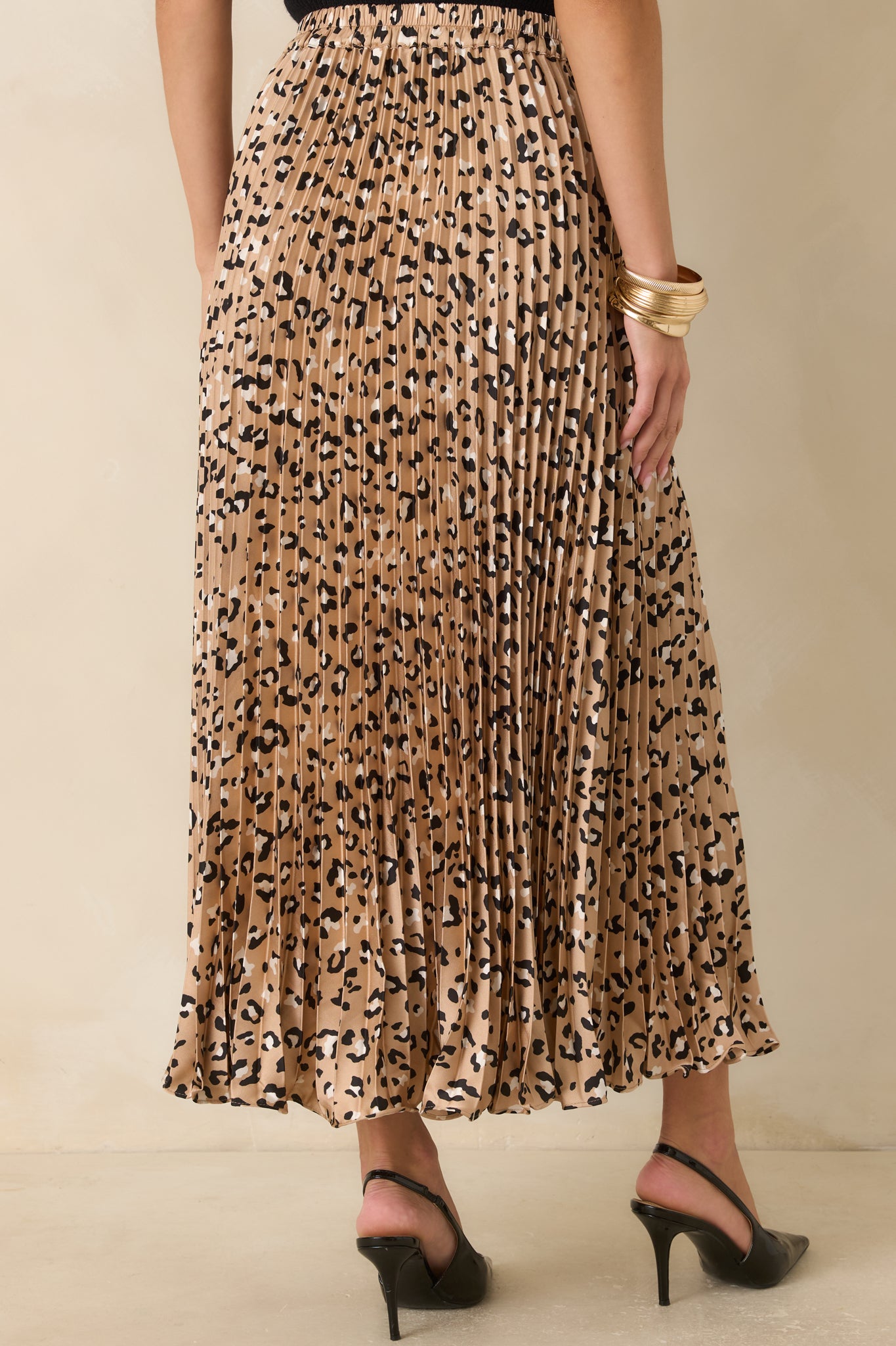 Back view of the leopard print satin maxi skirt featuring a flowing pleated silhouette and elastic waistband.