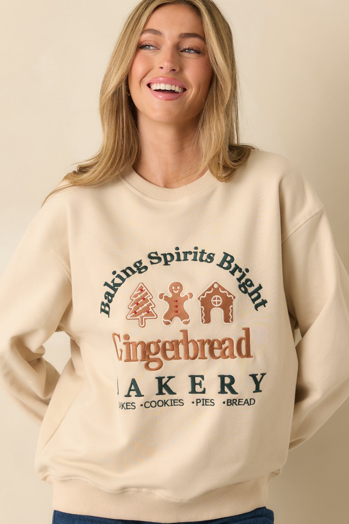 Light beige fleece sweatshirt highlighting the intricate bakery-themed elements and soft fleece texture.