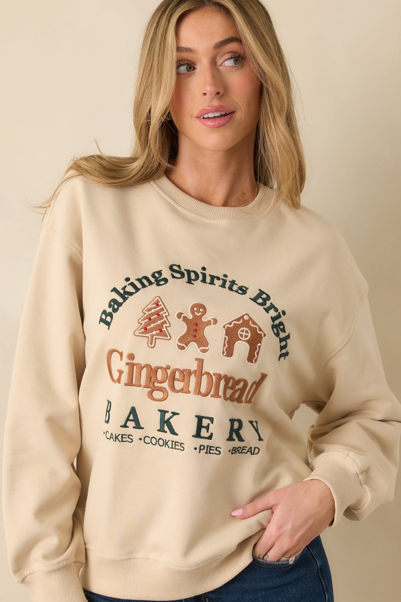 Light beige fleece sweatshirt featuring the ribbed neckline and upper embroidery details.