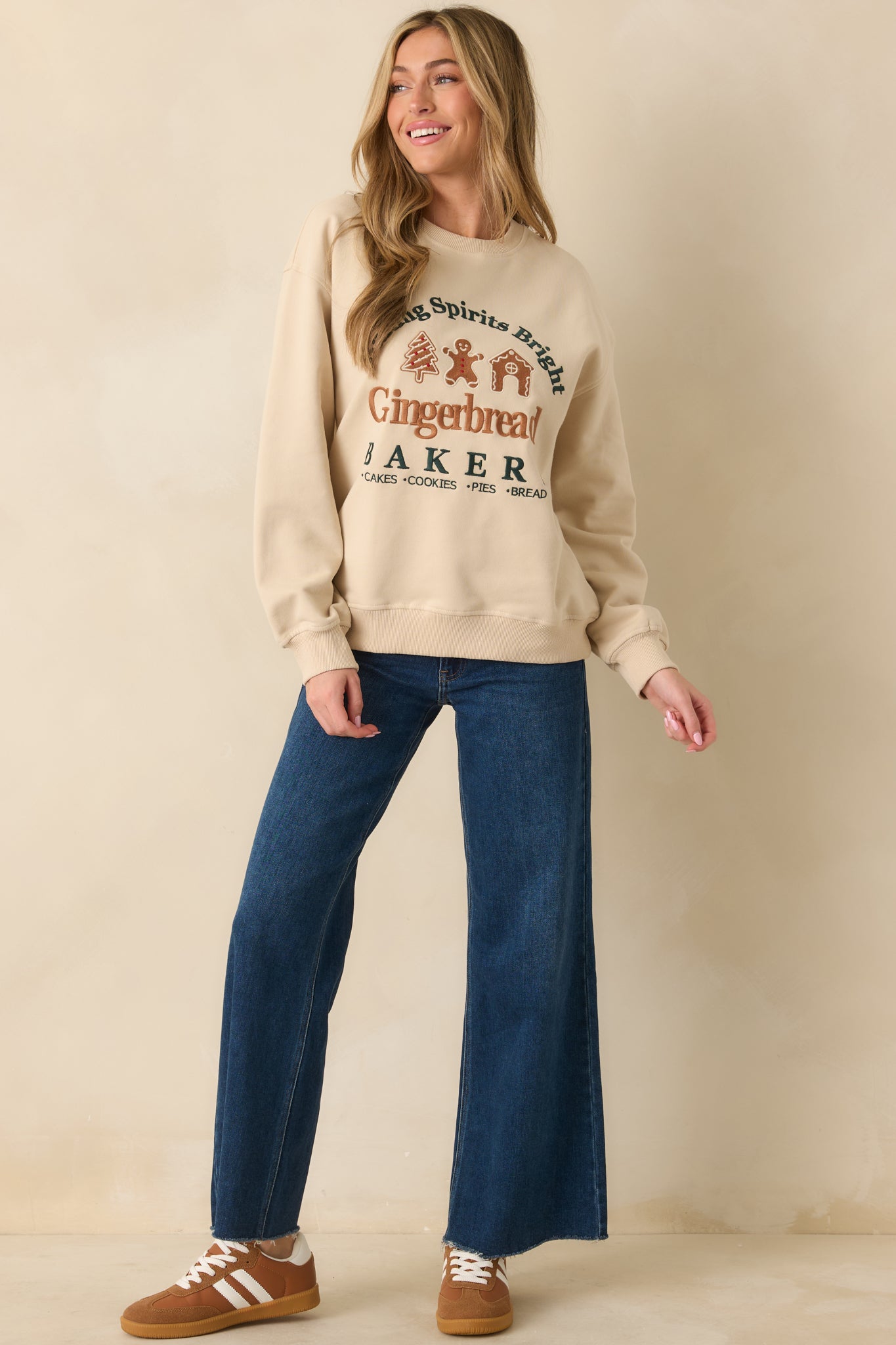 Light beige fleece sweatshirt displaying the ribbed trim and full gingerbread bakery motif.