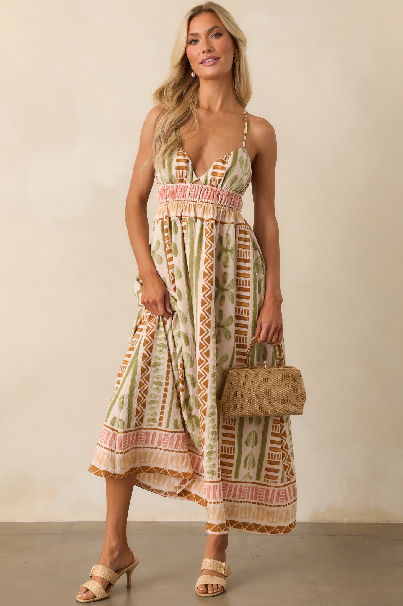 Front view of the light beige maxi dress highlighting the deep v-neckline and geometric tropical print.