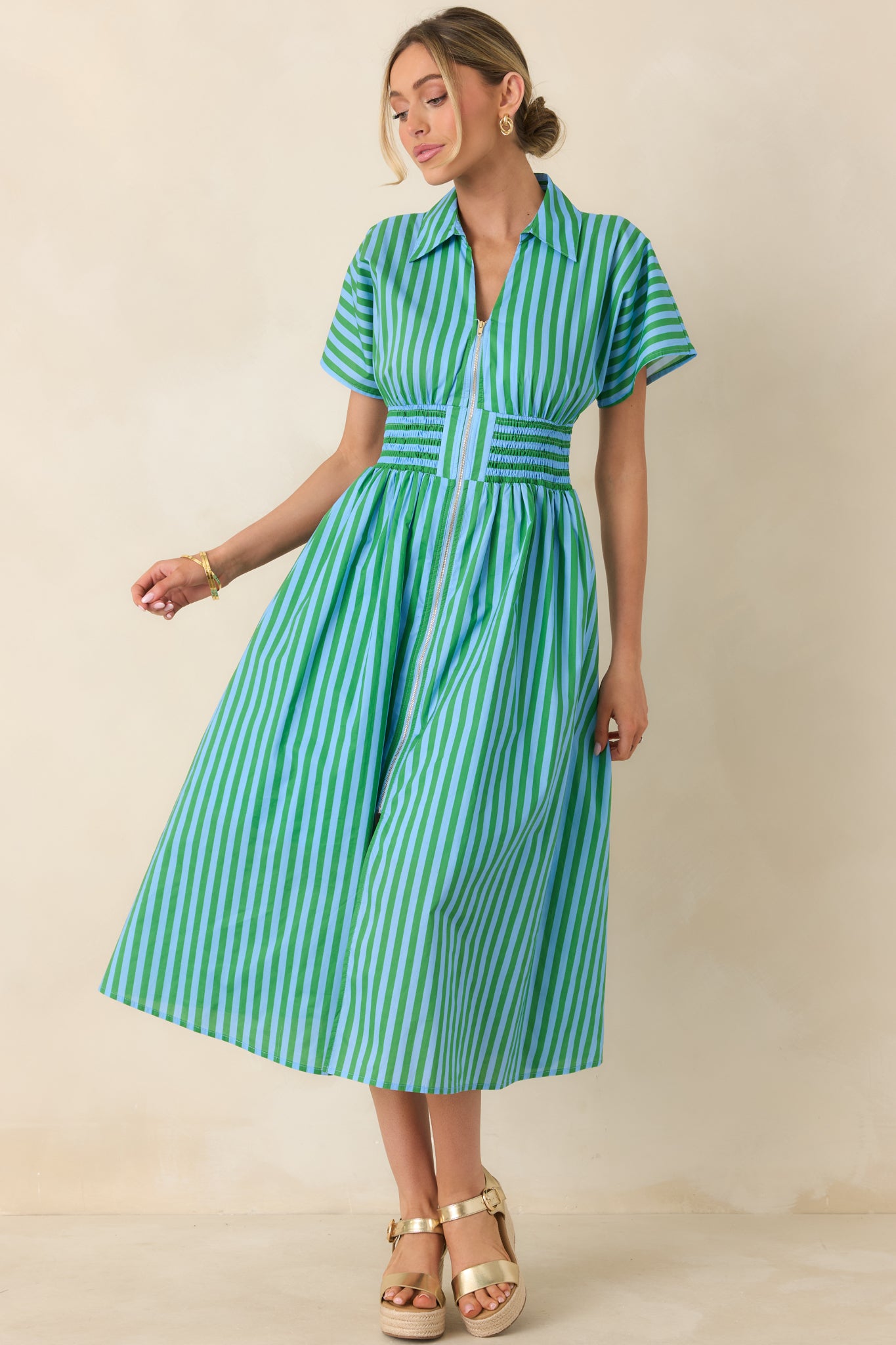 Light blue and green striped cotton midi dress with a smocked waist, short sleeves, and zip-front closure.