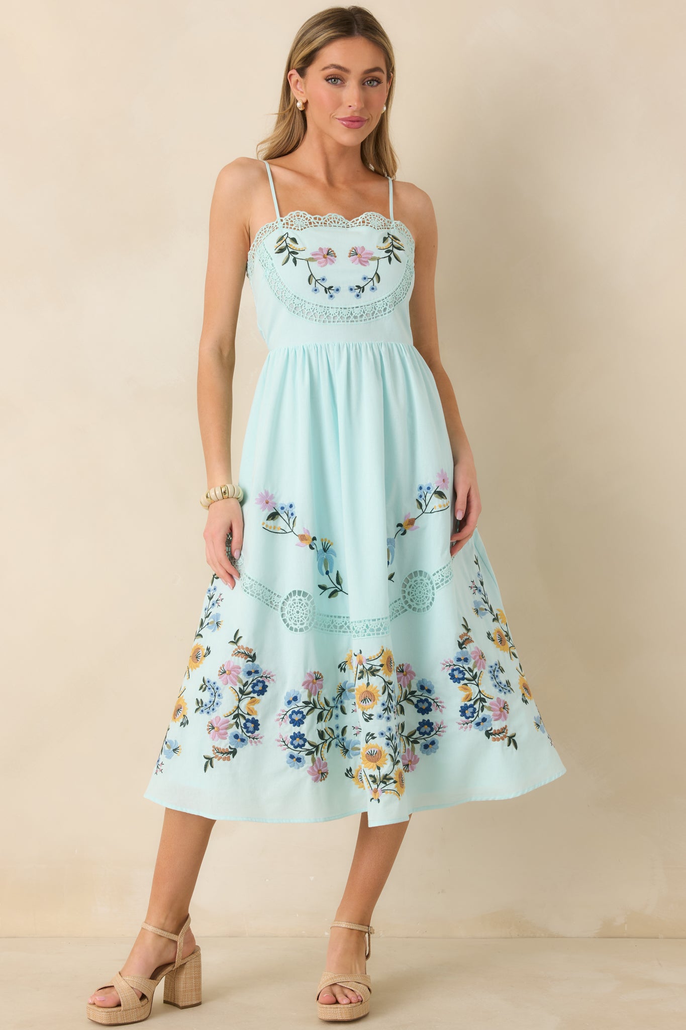 Light blue dress with adjustable straps, multicolor floral accents, and intricate ladder-style lace detailing.