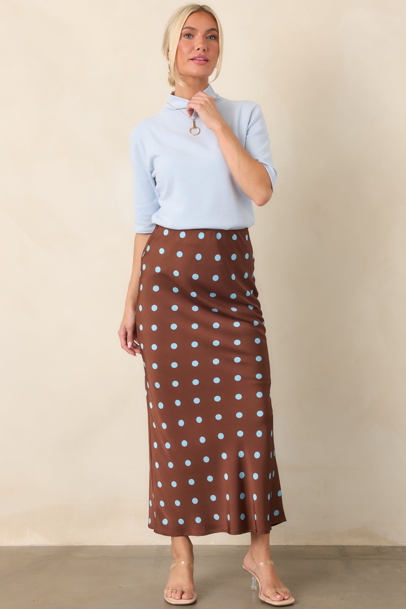 Light blue fitted knit top with a clean mock neckline, elbow-grazing sleeves, and an understated polished finish.