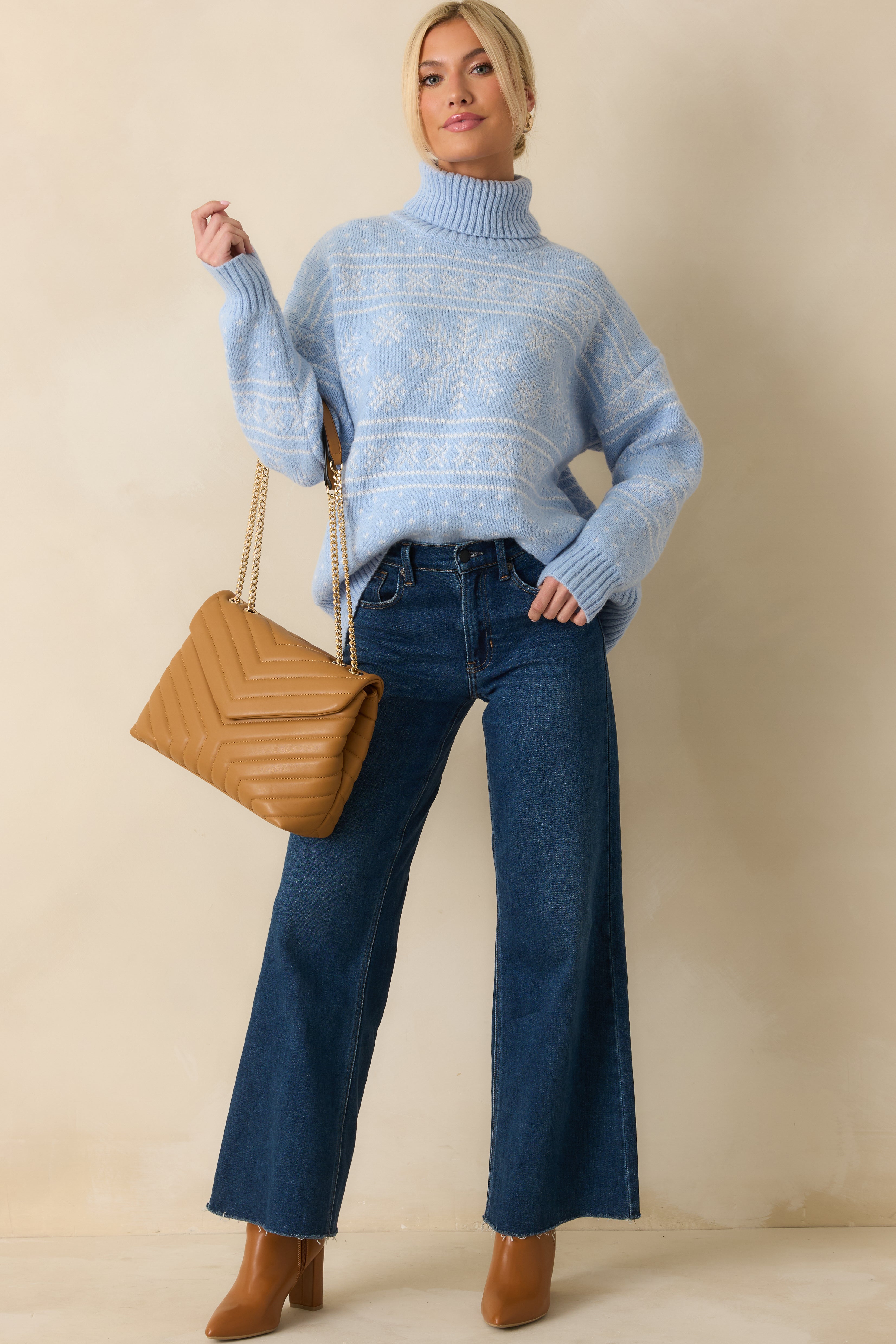 Light blue knit turtleneck sweater featuring a snowflake and fair-isle pattern with a soft, cozy look.