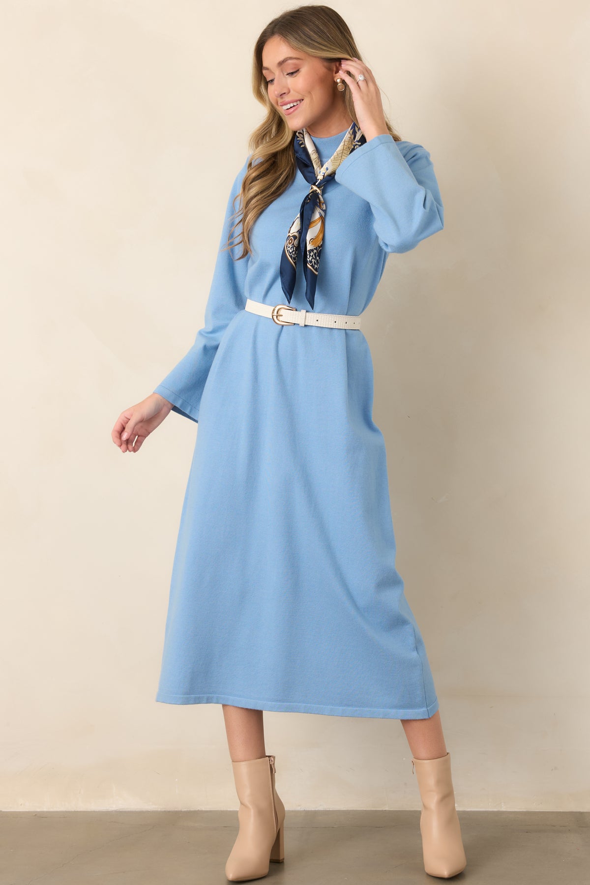 Light blue shift dress showcasing a minimalist design, relaxed fit, long sleeves, and streamlined midi-length silhouette.