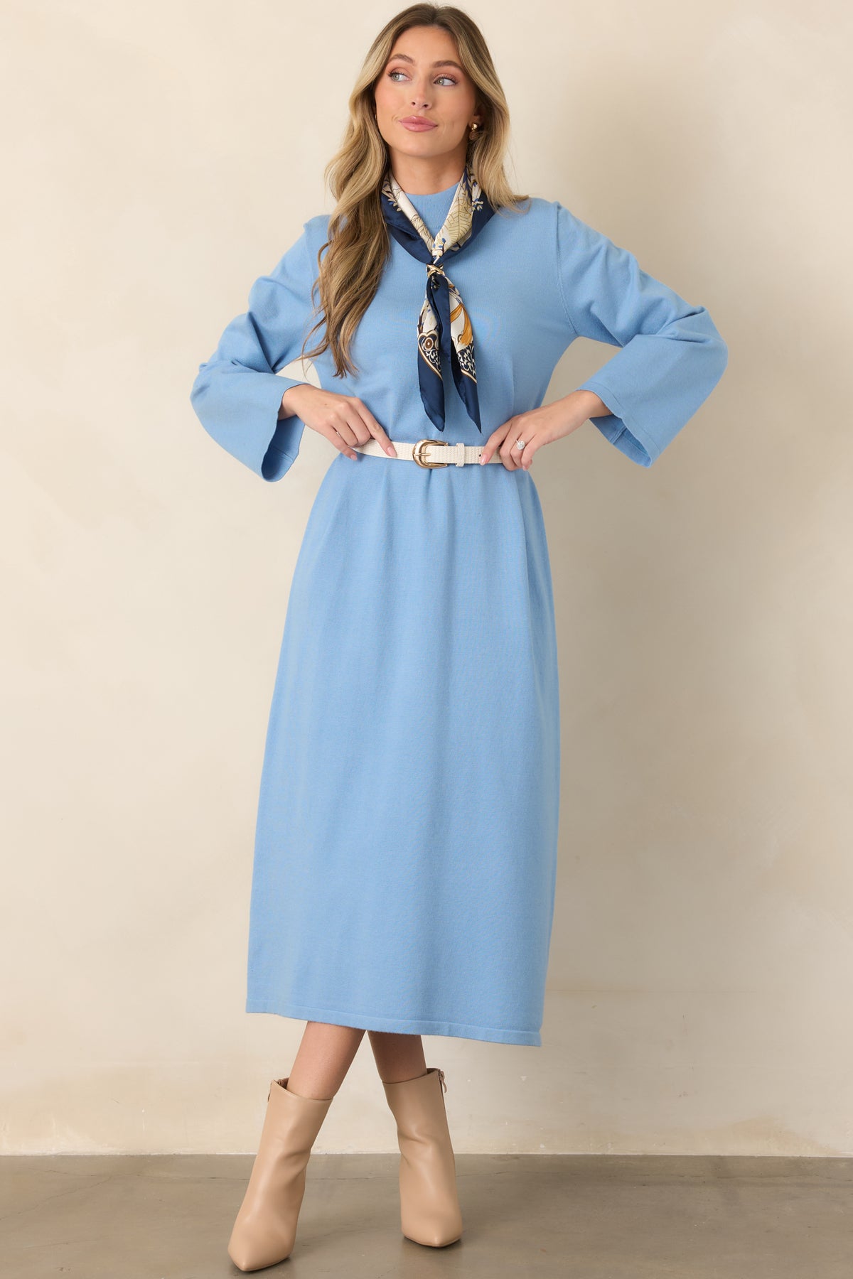 Light blue midi dress showcasing a softly structured shift shape, high mock neckline, long sleeves, and fluid stretch-knit construction.