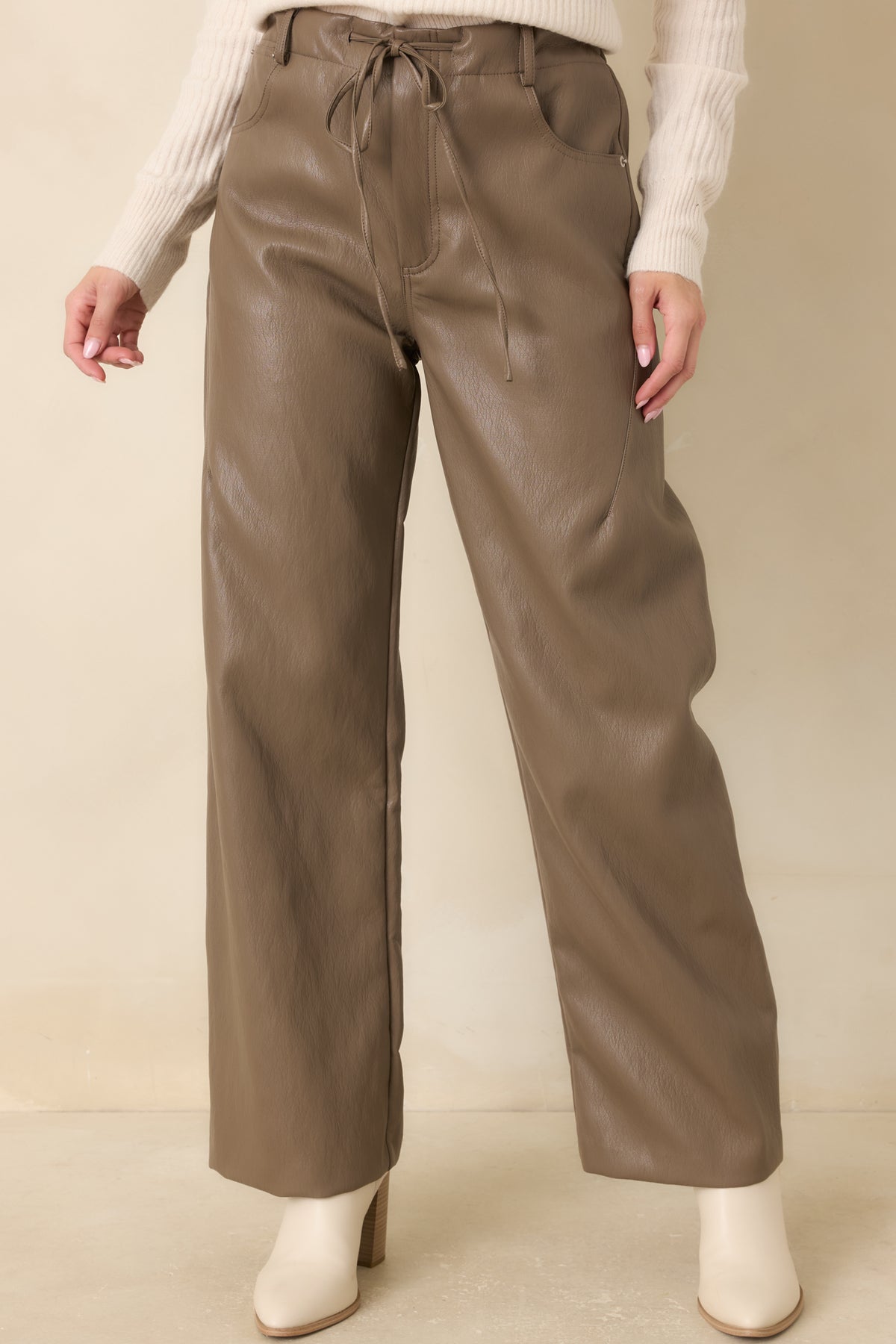 Light brown faux leather pants highlighting the elastic waistband and front drawstring tie.