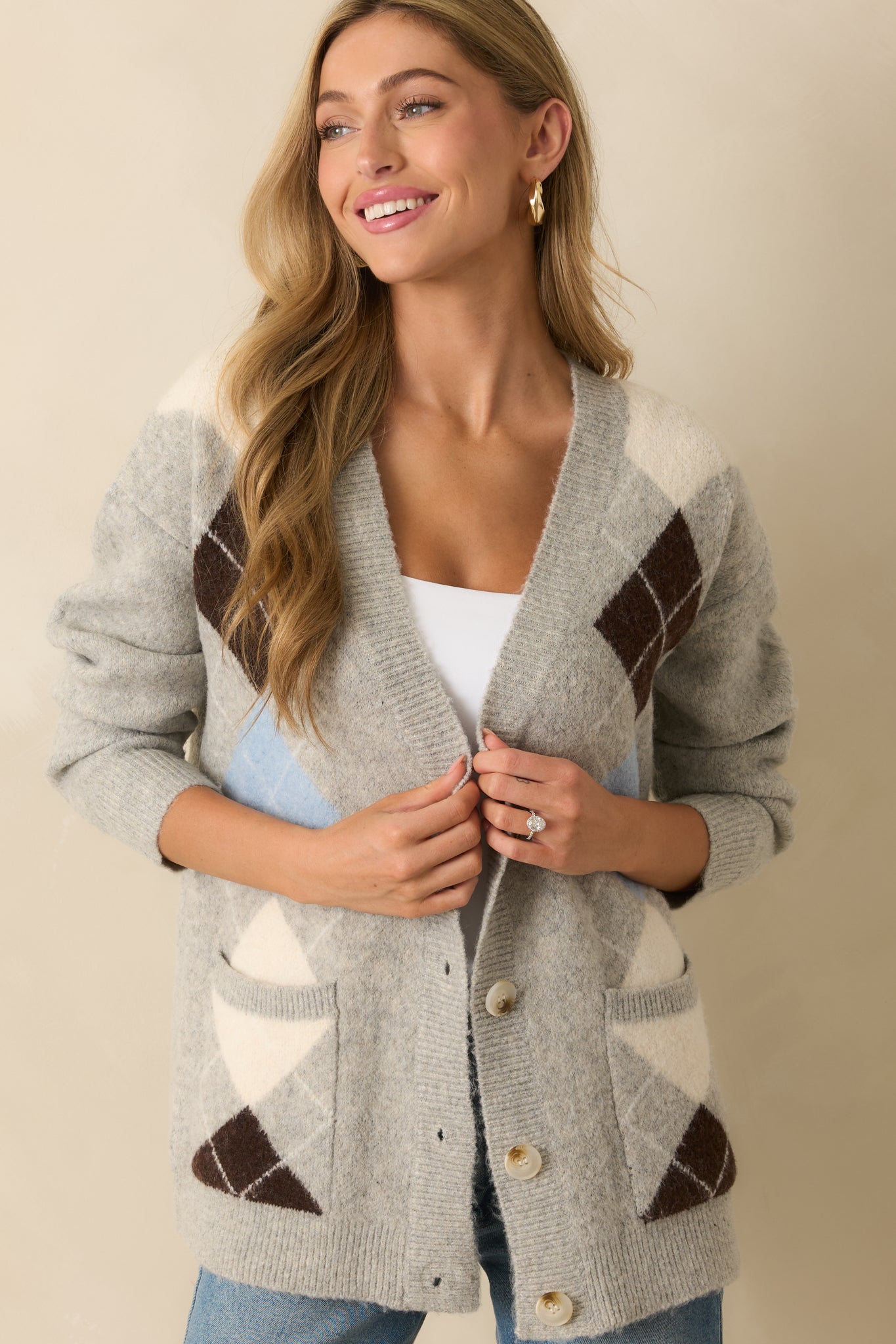 A cropped front view focusing on the argyle pattern and button placket of the cardigan.
