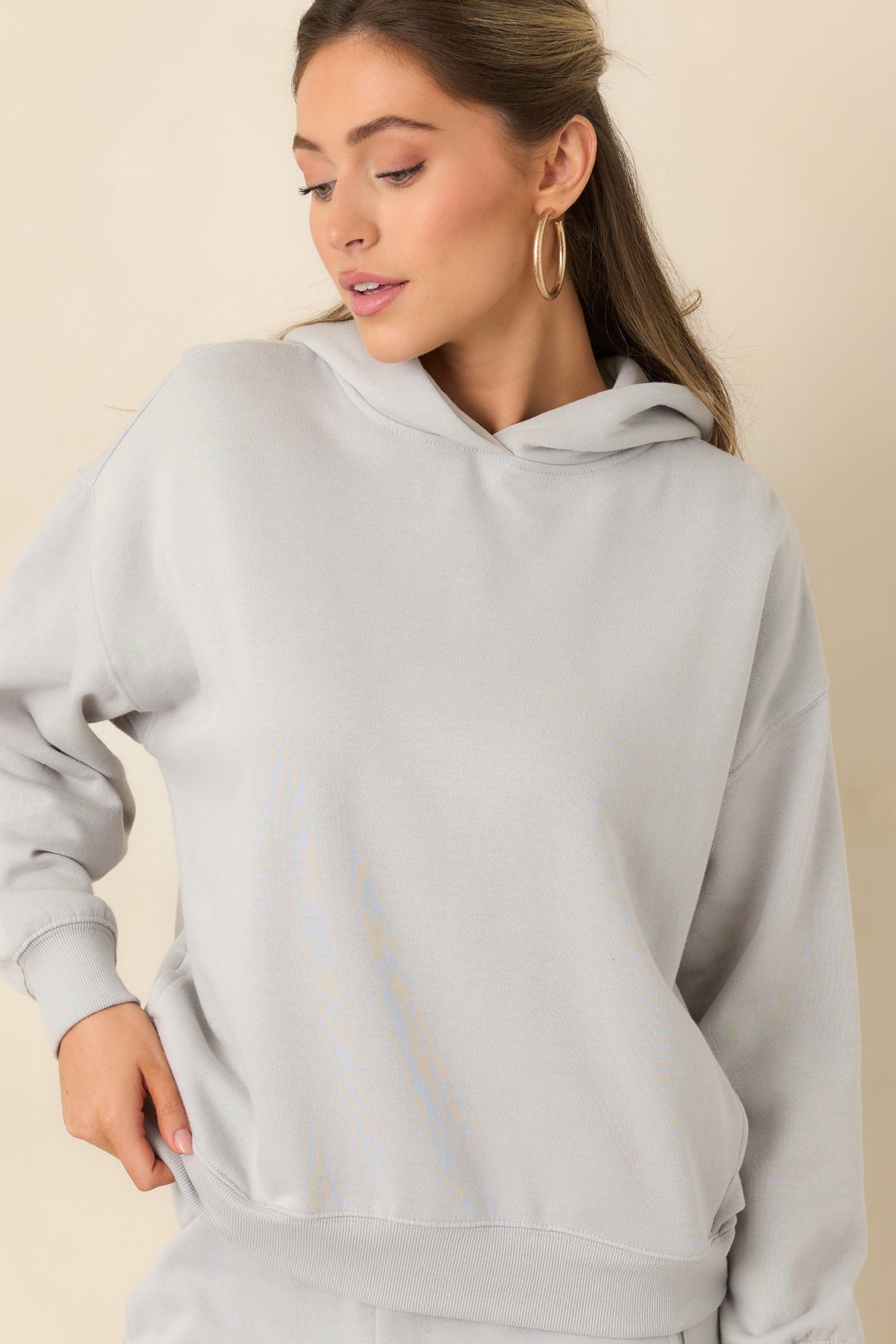 Light grey fleece hoodie featuring ribbed cuffs that finish the roomy sleeves.
