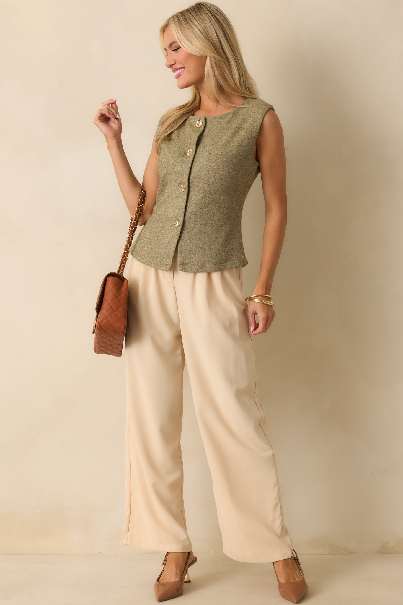Light olive green knit vest with hammered gold buttons displayed from the front, emphasizing the clean, structured fit.