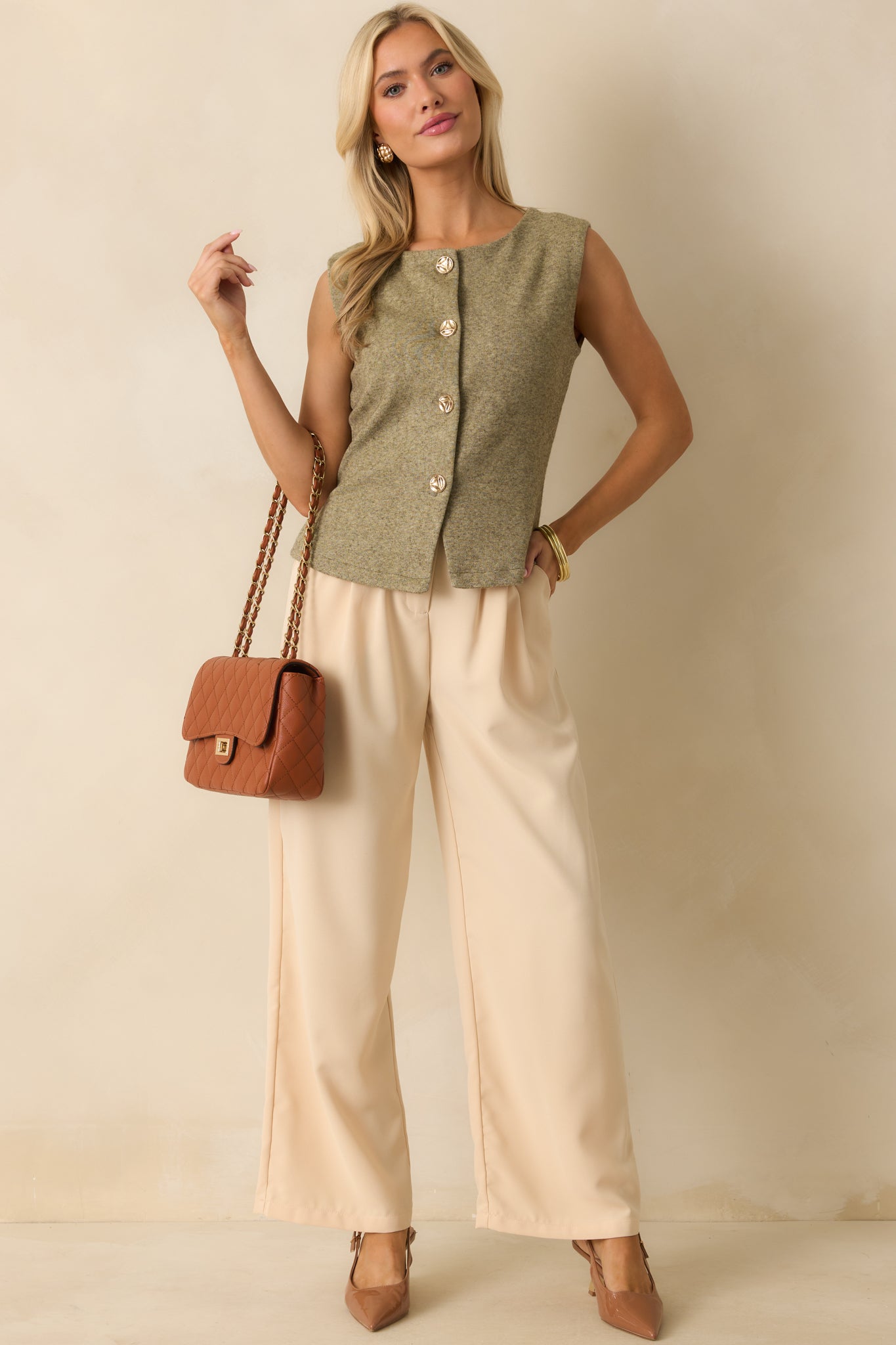 Light olive green knit vest displayed front facing, highlighting the sleeveless silhouette, functional gold button closure, and relaxed straight hemline.