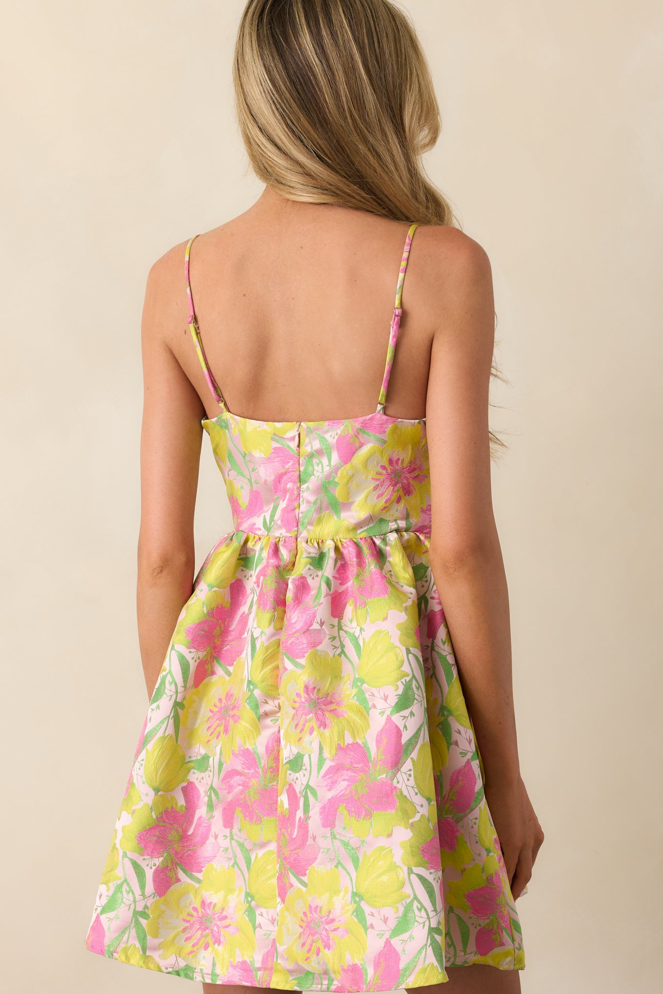 A view from behind showing the discrete zipper and adjustable straps of the light pink dress.