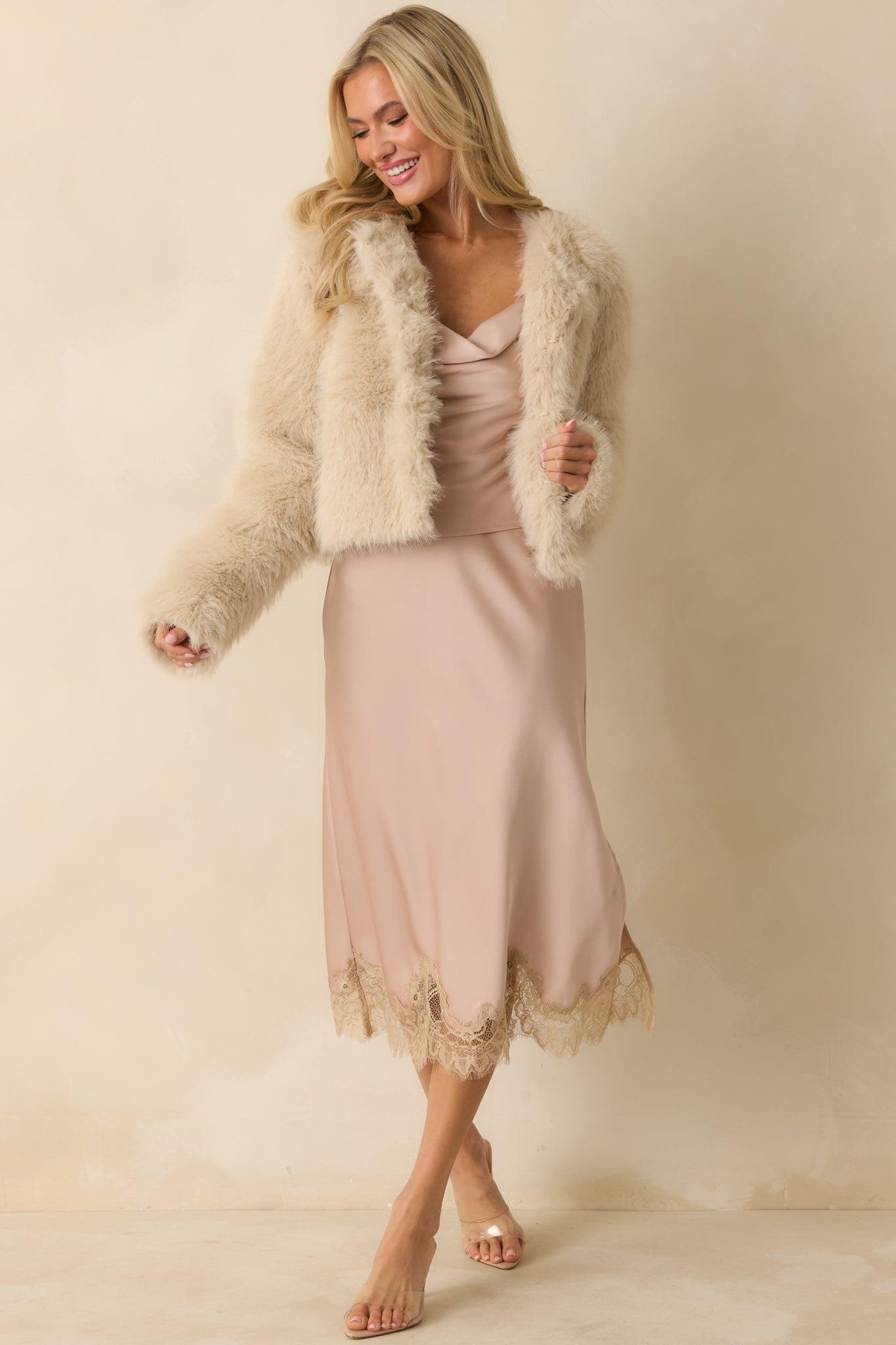 Light pink satin top with a flowy neckline and subtle cropped cut.