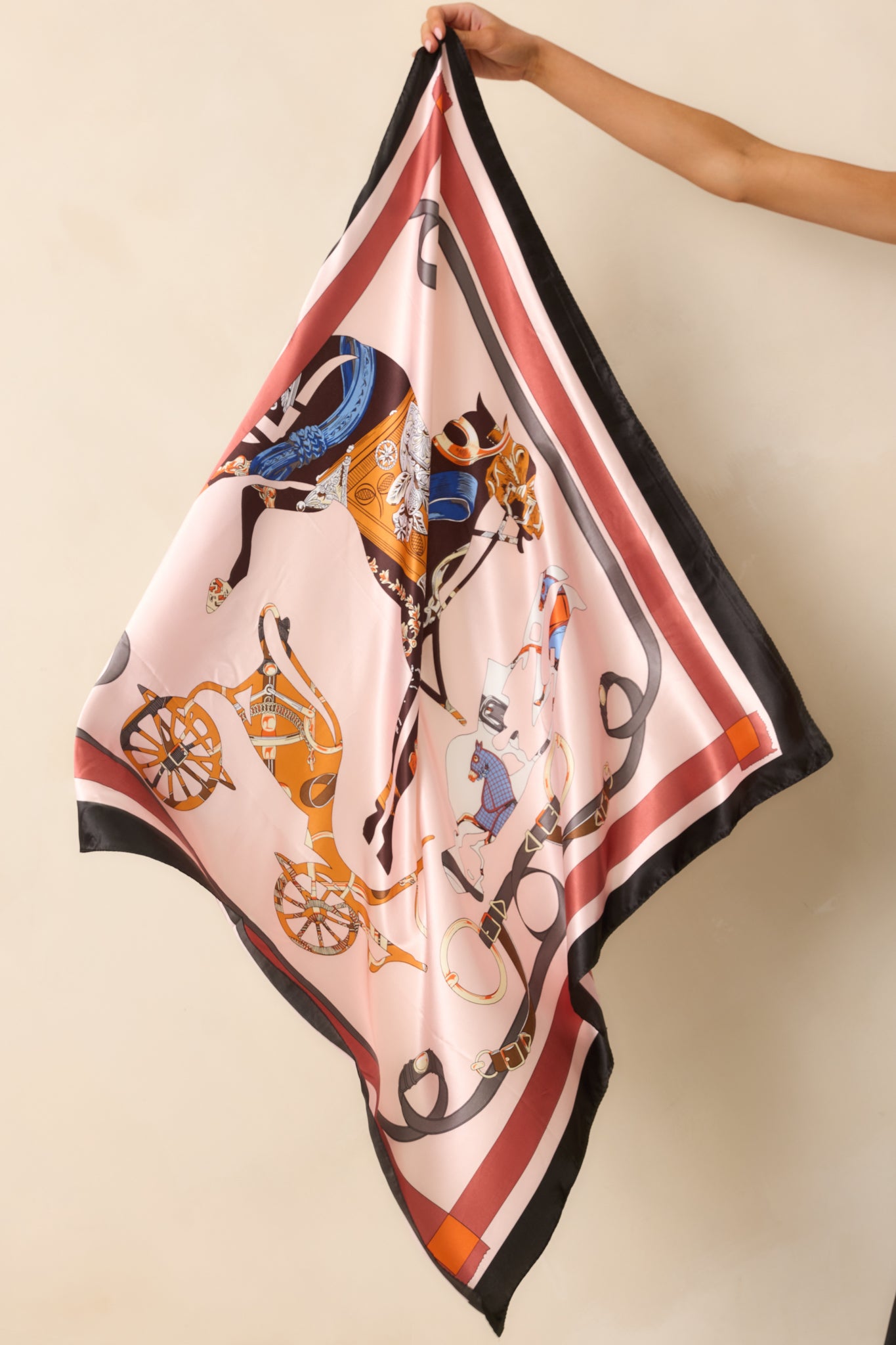 The light pink square scarf displayed in its entirety to show the equestrian horse and carriage print with multicolor detailing.