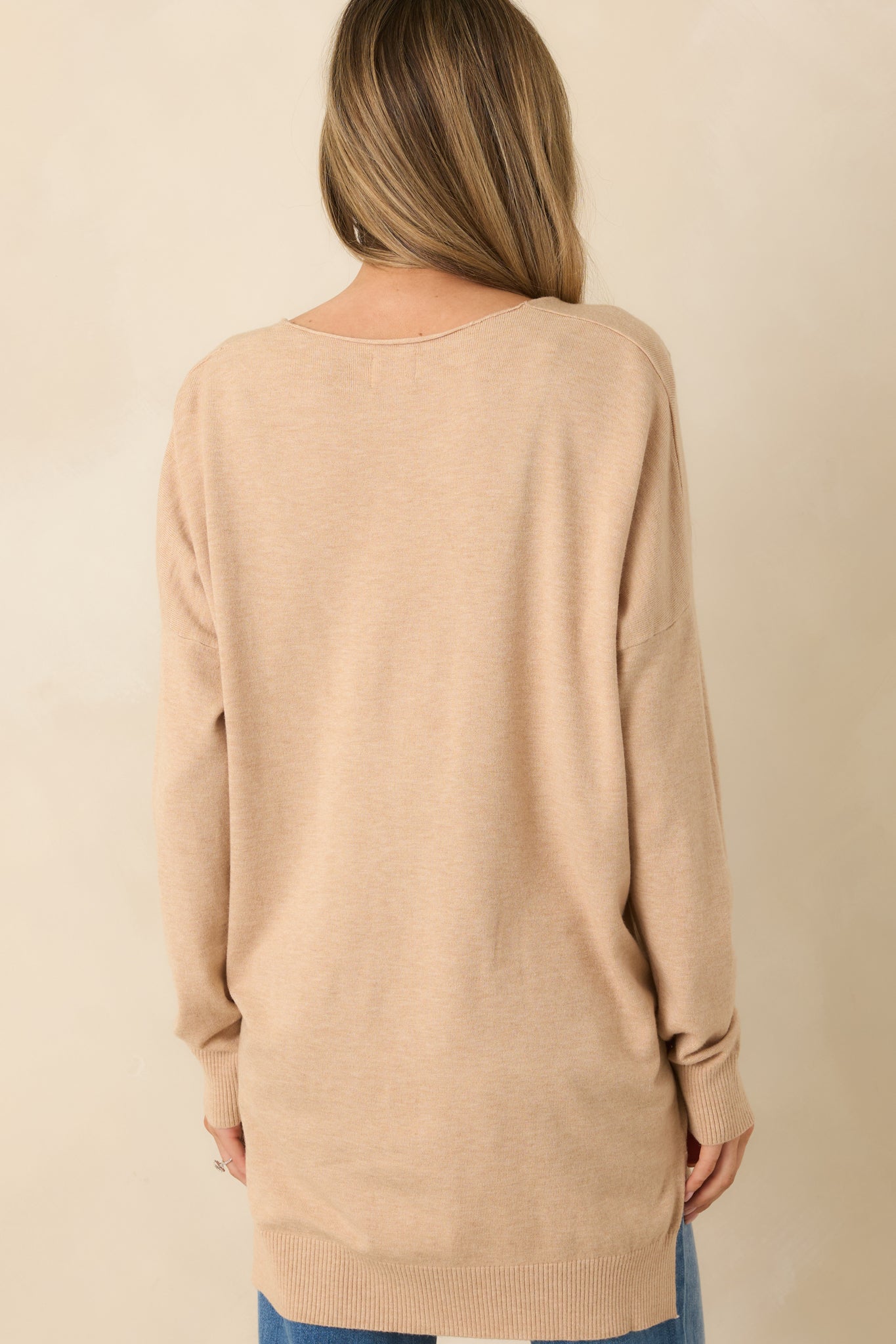 Light taupe knit sweater shown from the rear, highlighting the slightly longer back hem and relaxed fit.