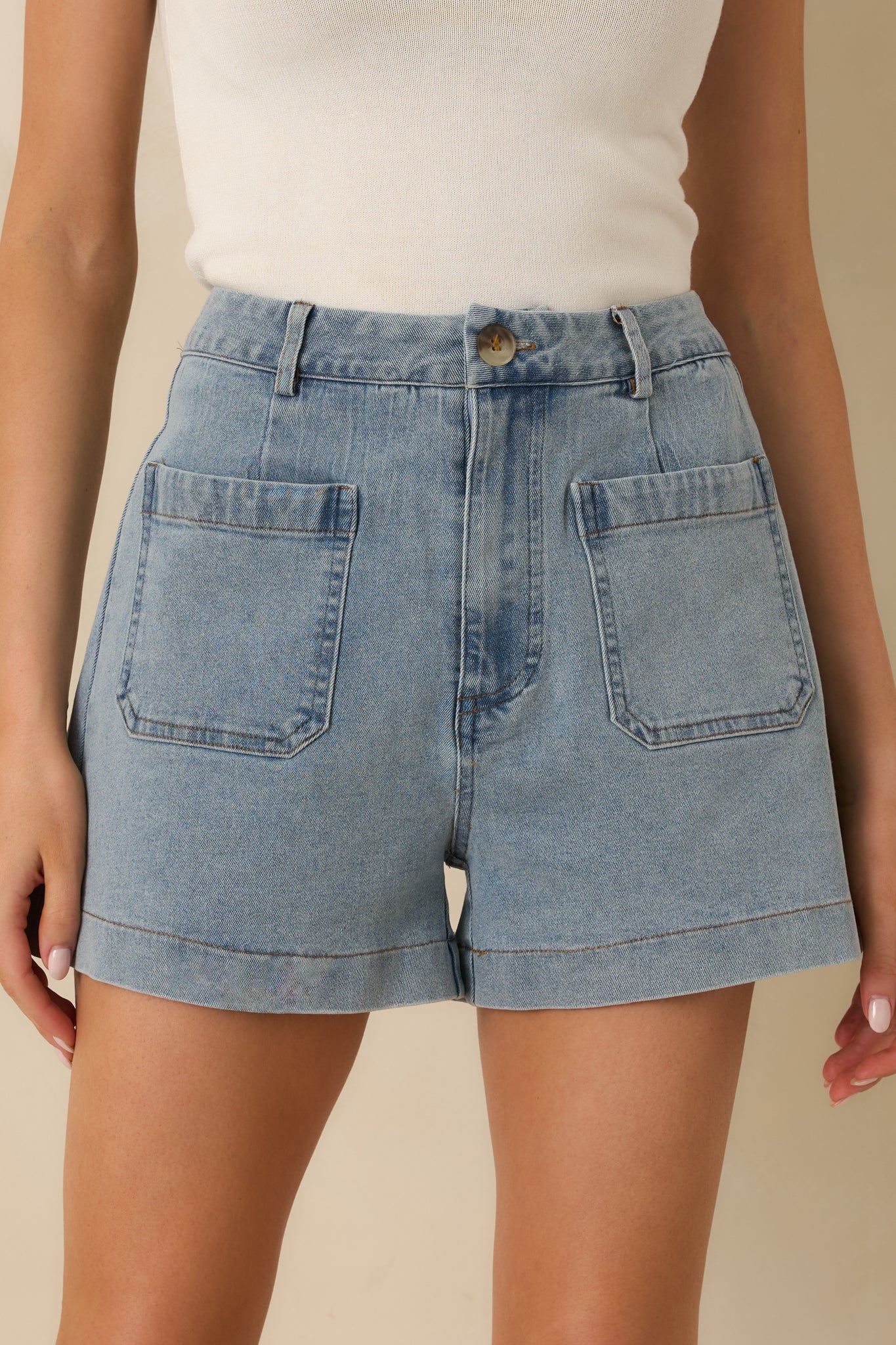 Light wash denim shorts emphasizing the structured hip fit and clean hemline.