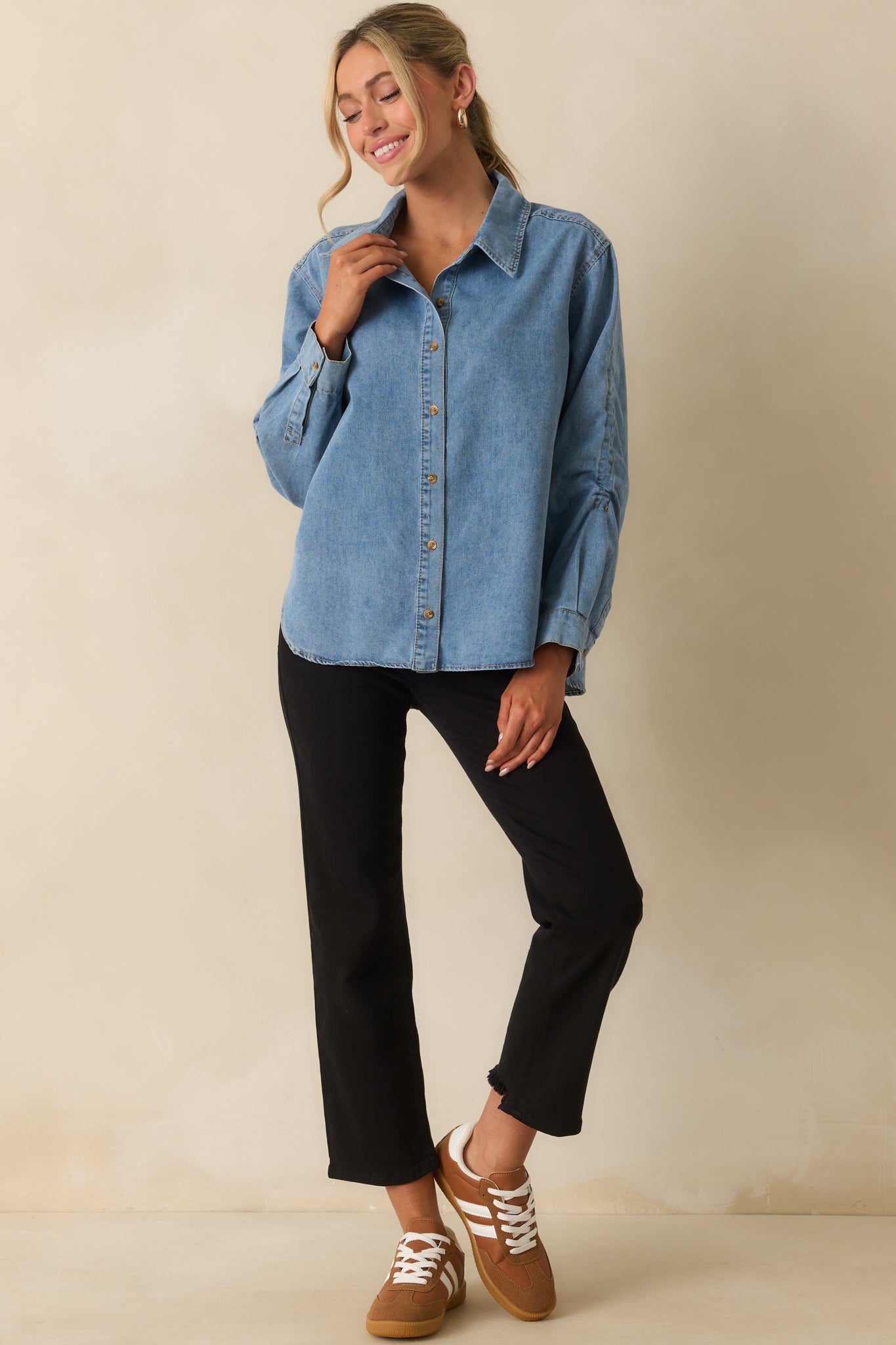 Light wash denim top with collared neckline and long sleeves with button cuffs.