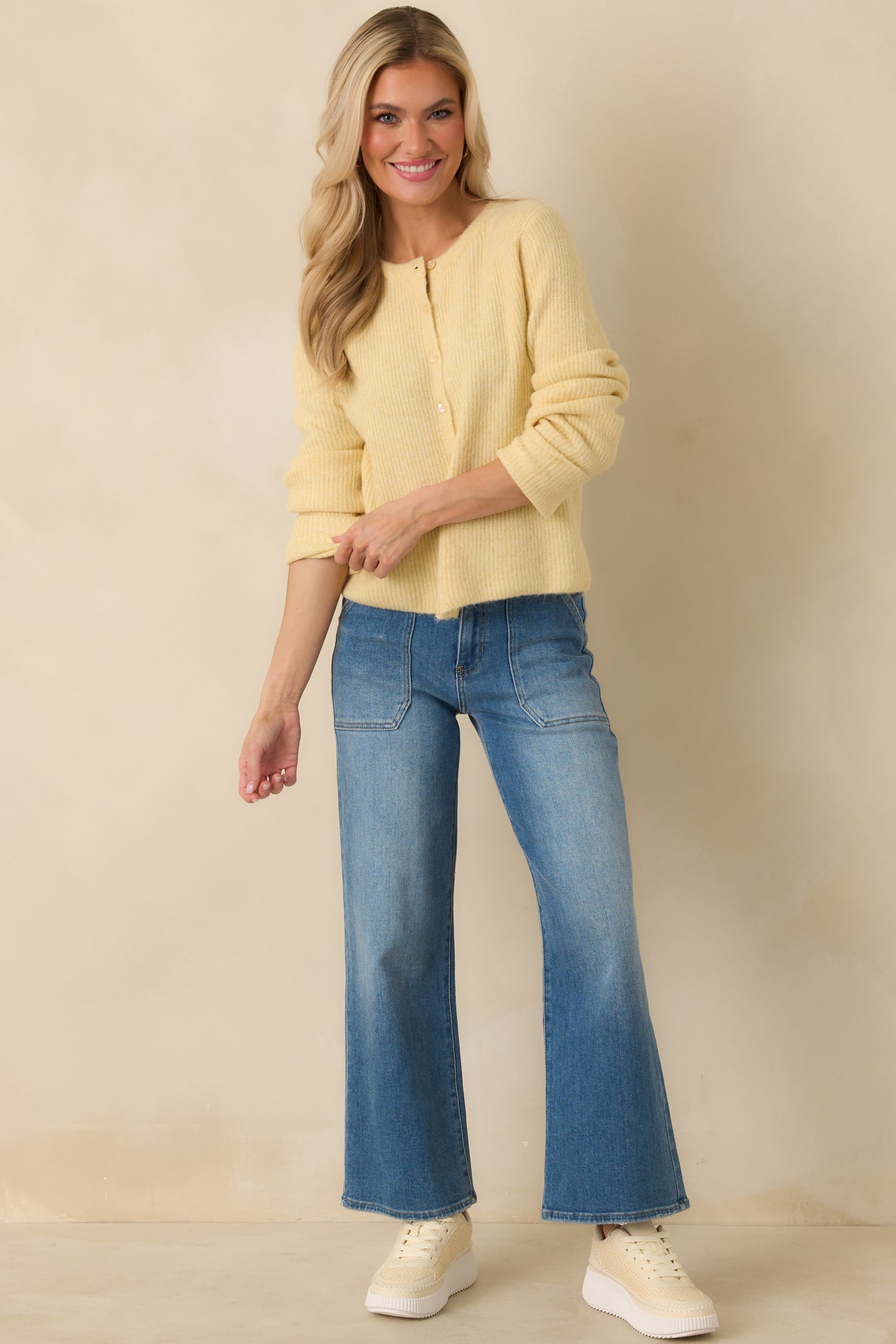 Light yellow knit cardigan designed with long sleeves, a clean crew neckline, and subtle ribbing for a polished look.