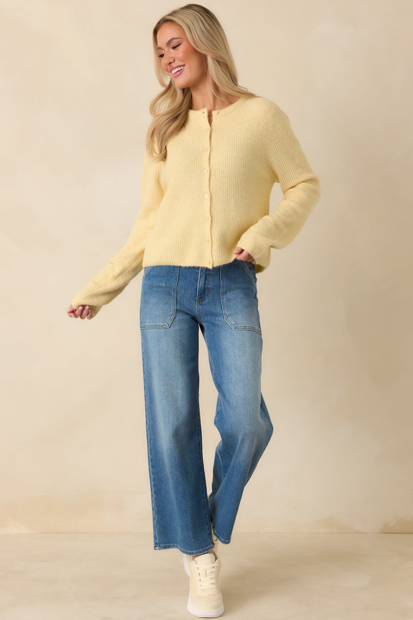 Light yellow ribbed knit cardigan with a relaxed, slightly fitted silhouette, classic crew neckline, and long sleeves.