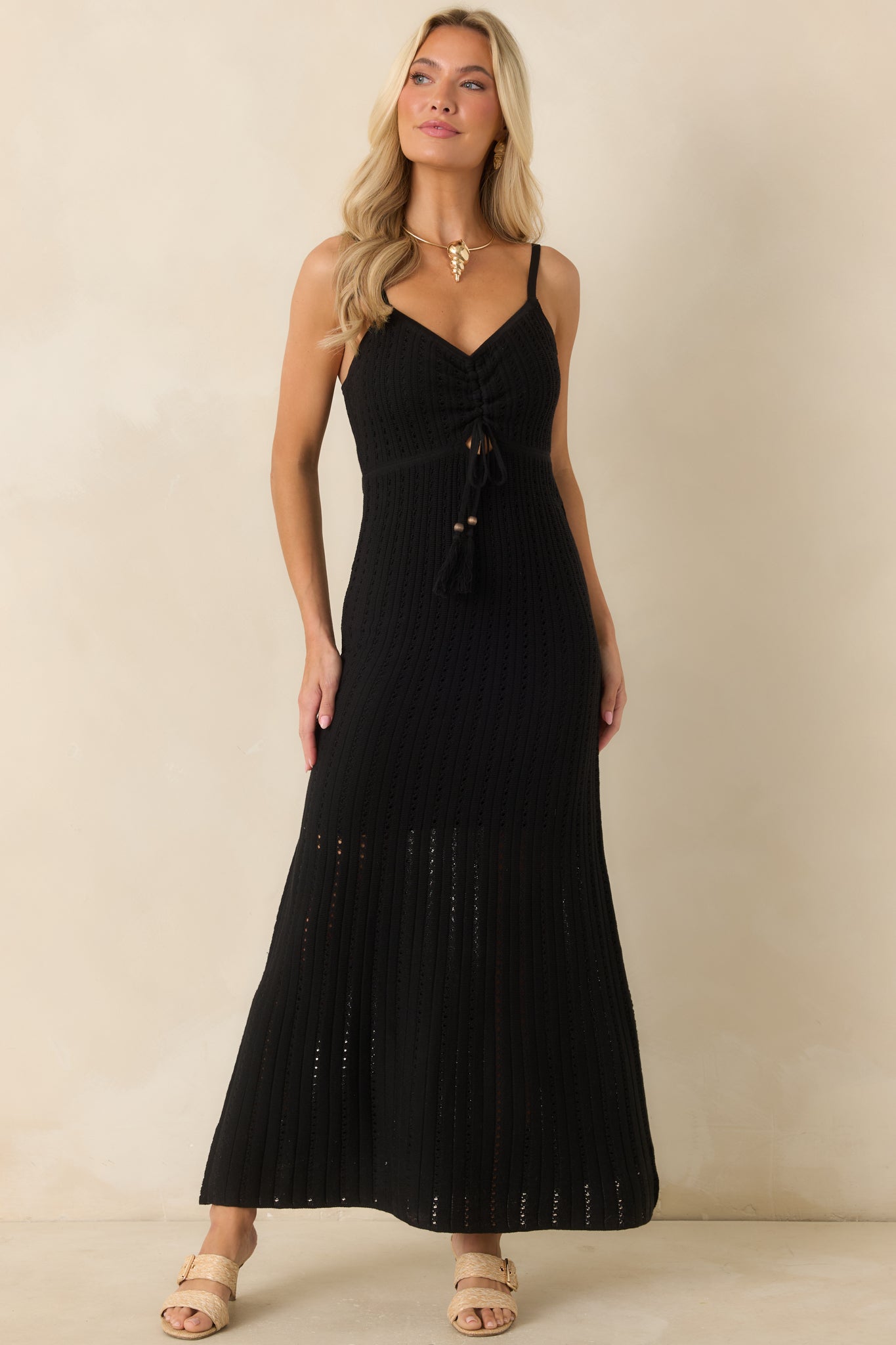 Lightweight black crochet maxi dress with a V-neckline, adjustable tie accents, and an elegant fitted silhouette.