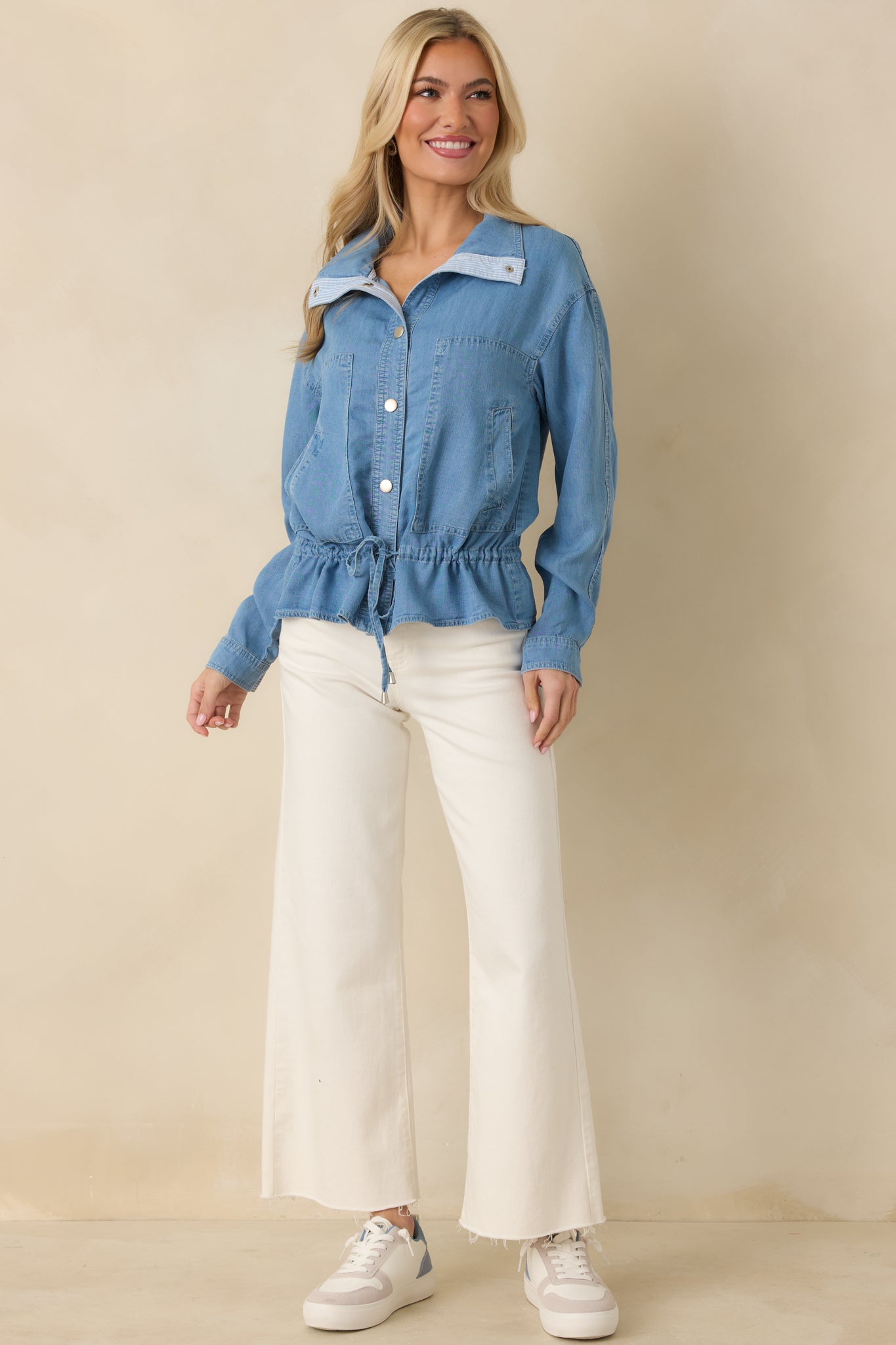 Lightweight denim top designed with a relaxed fit, silver snaps, and cinched waist detail.