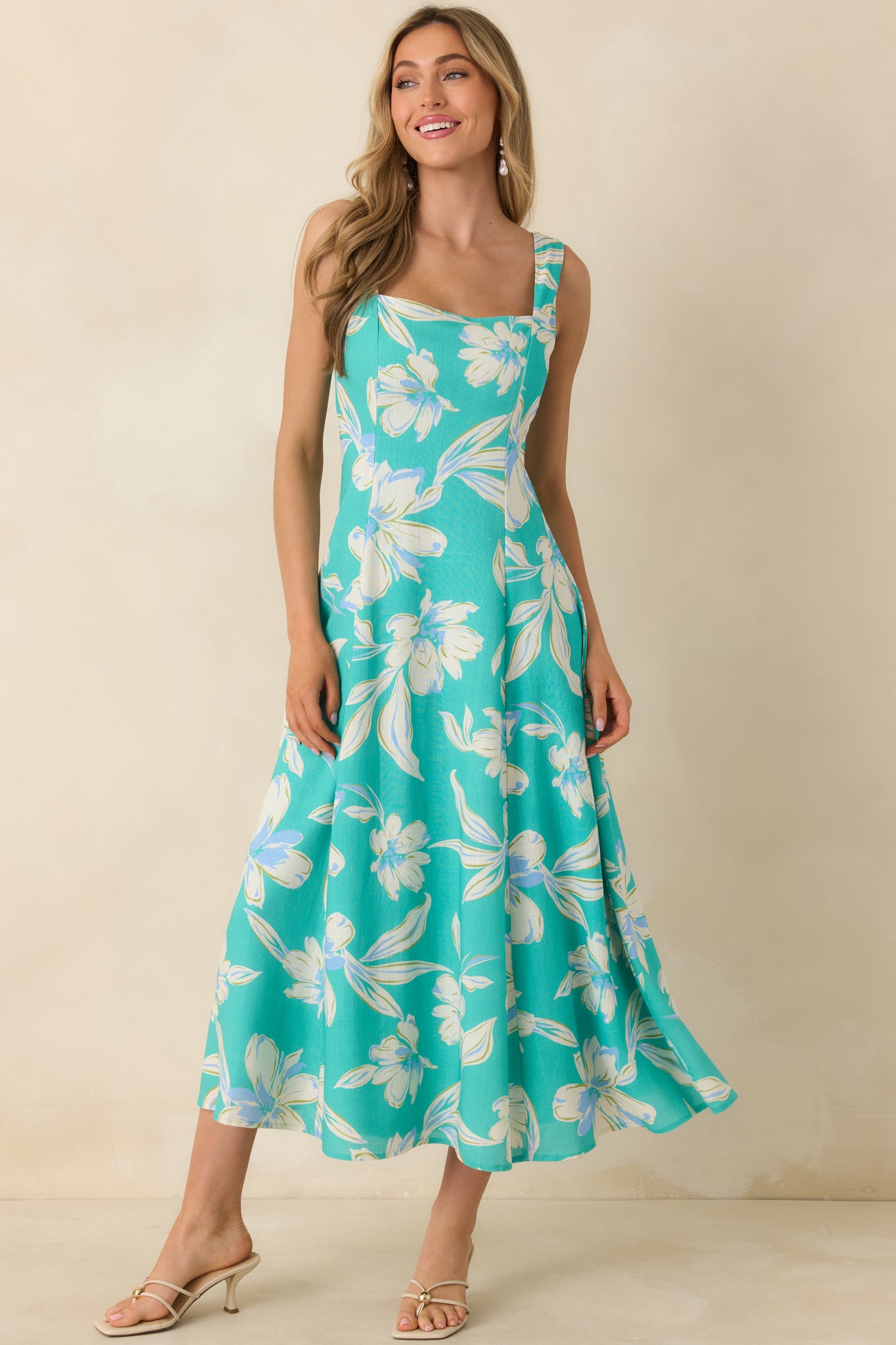 Lightweight turquoise dress with structured upper body, square neckline, and soft skirt flare to midi length.