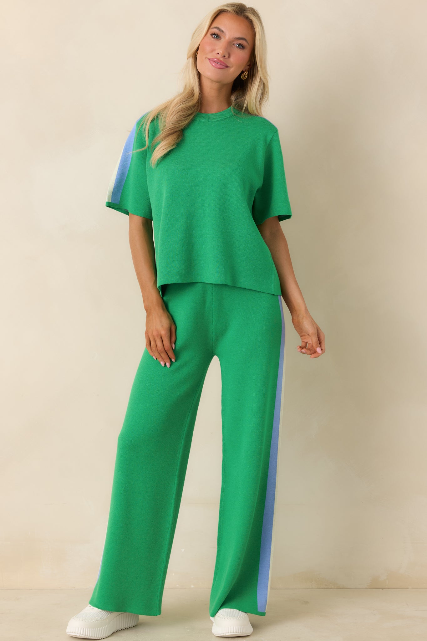 Lightweight green top featuring multi-colored stripe trim on shoulders and sleeves.