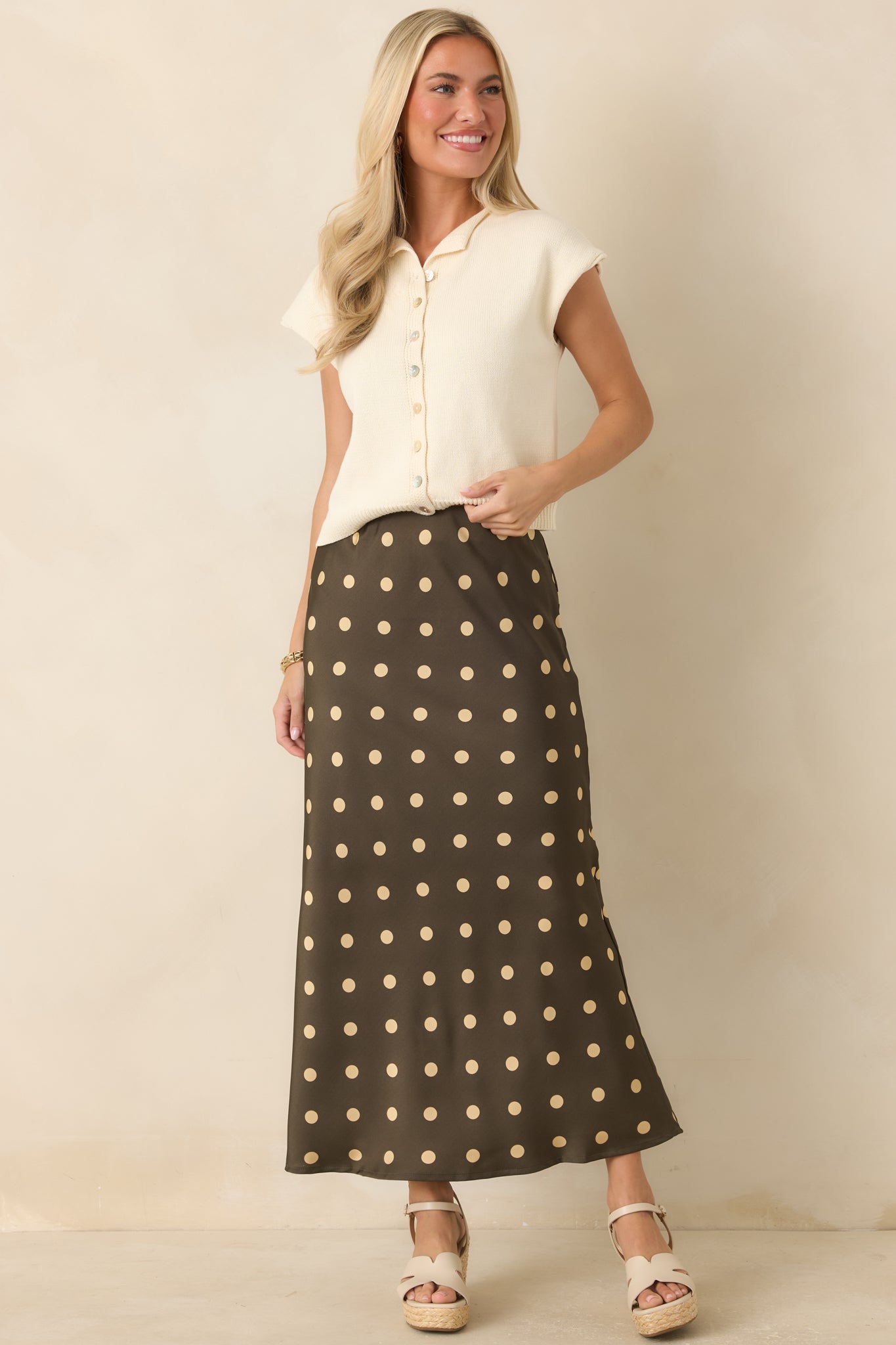 Lightweight ivory top designed with a relaxed fit, button front, and polished pearlescent details.