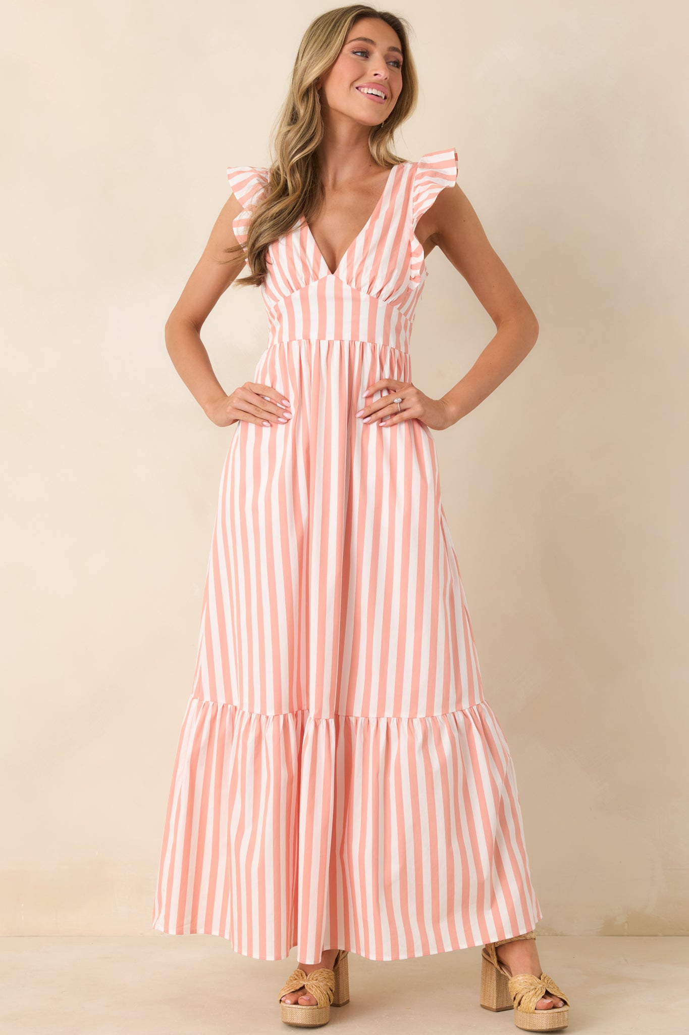 Lightweight maxi featuring structured wide straps with flutter detail, a flattering fitted bodice, and a soft tiered skirt for graceful movement.