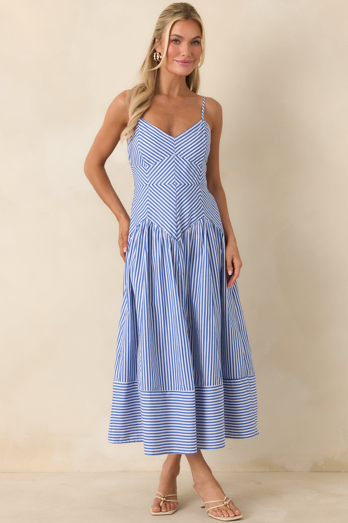 Lightweight midi dress featuring smocked back and feminine flowing silhouette.